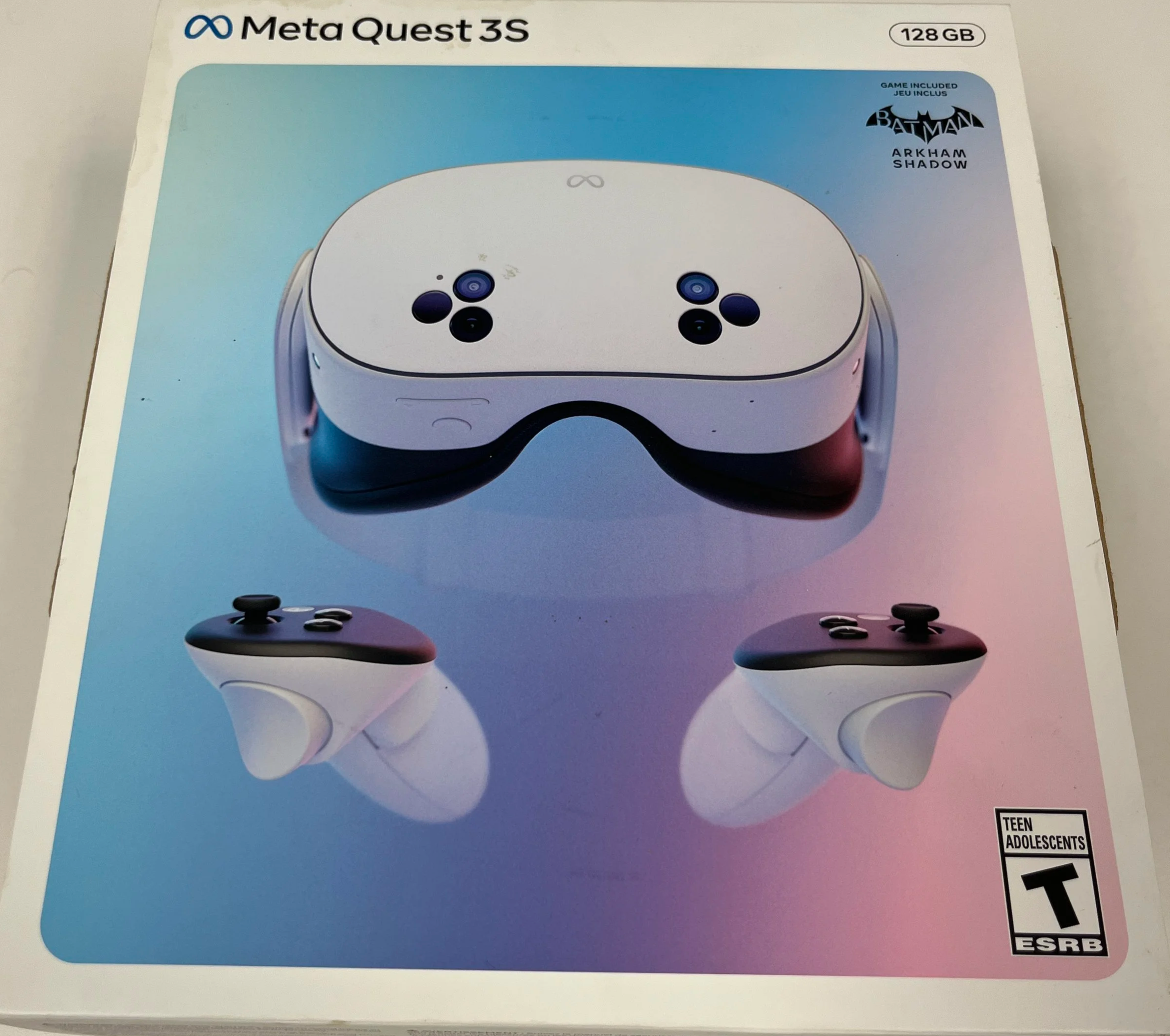 Box for Meta Quest 3S virtual reality headset with controllers, showing the headset and controllers on a gradient blue and pink background, with branding and game titles including Batman and Arkham Shadow.
