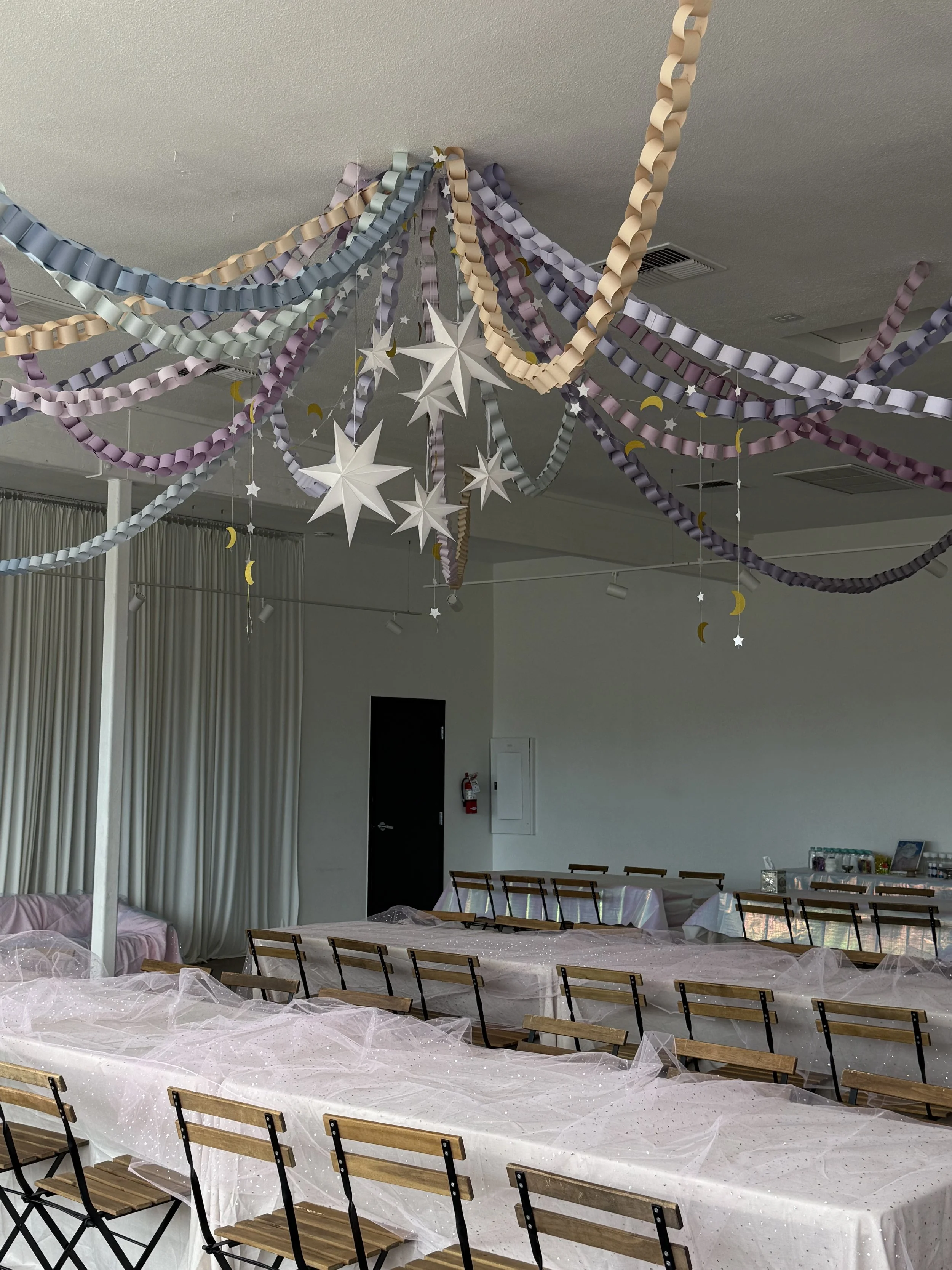 Rectangular white cake decorated with pink and red flowers and white piped icing, placed on a wooden board.