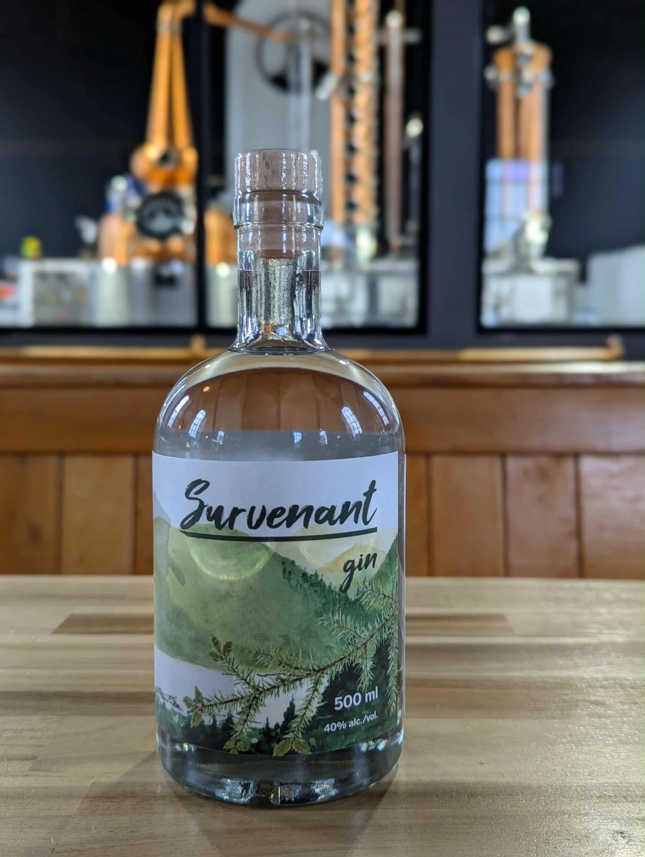 Bouteille de gin Survenant sur une table en bois, avec un fond de mur en bois et un miroir derrière, reflétant différents objets dans un espace intérieur.