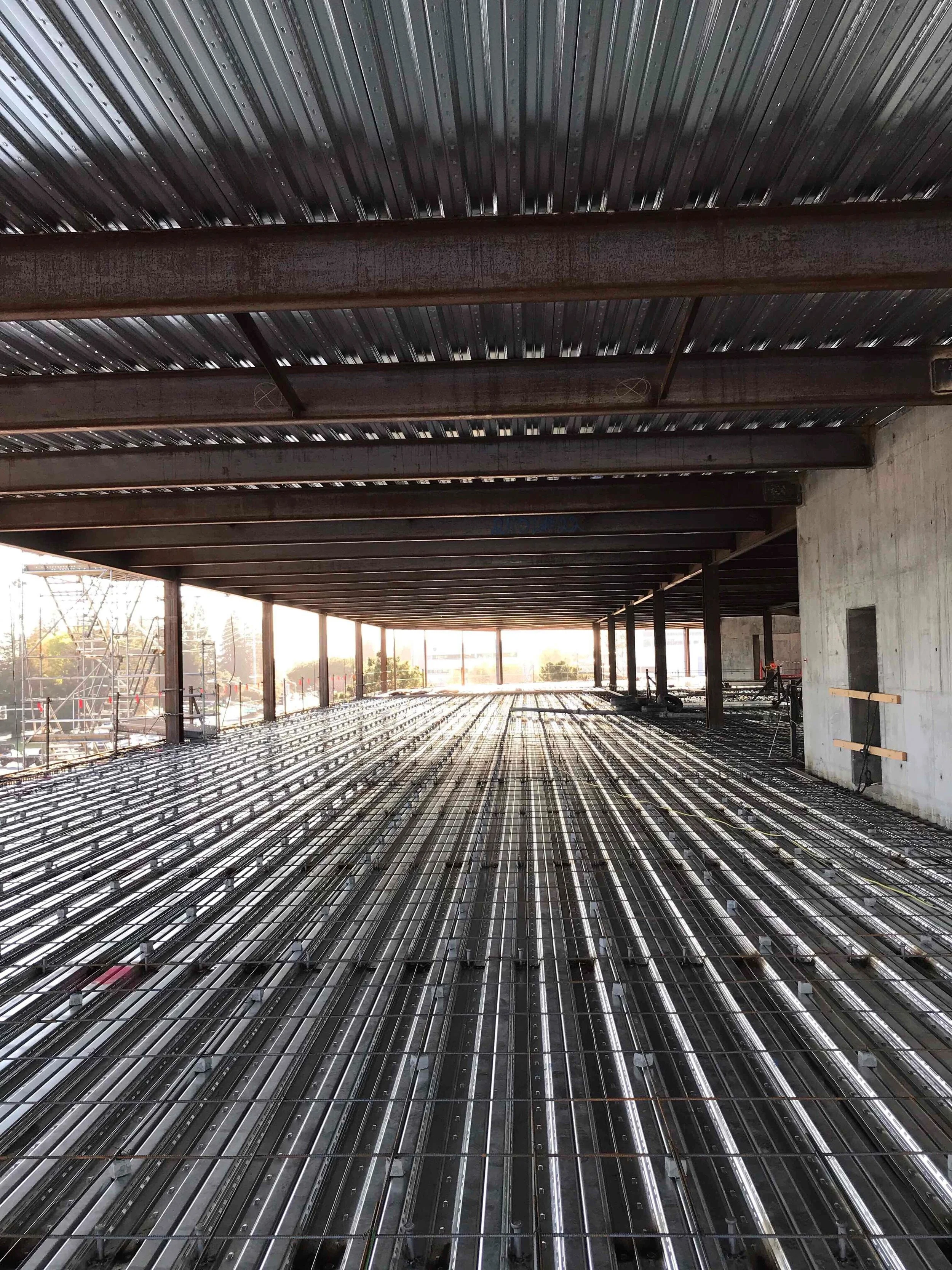 Metal pan deck with laid out rebar for a suspended slab, showing reinforcement placement prior to concrete pour.