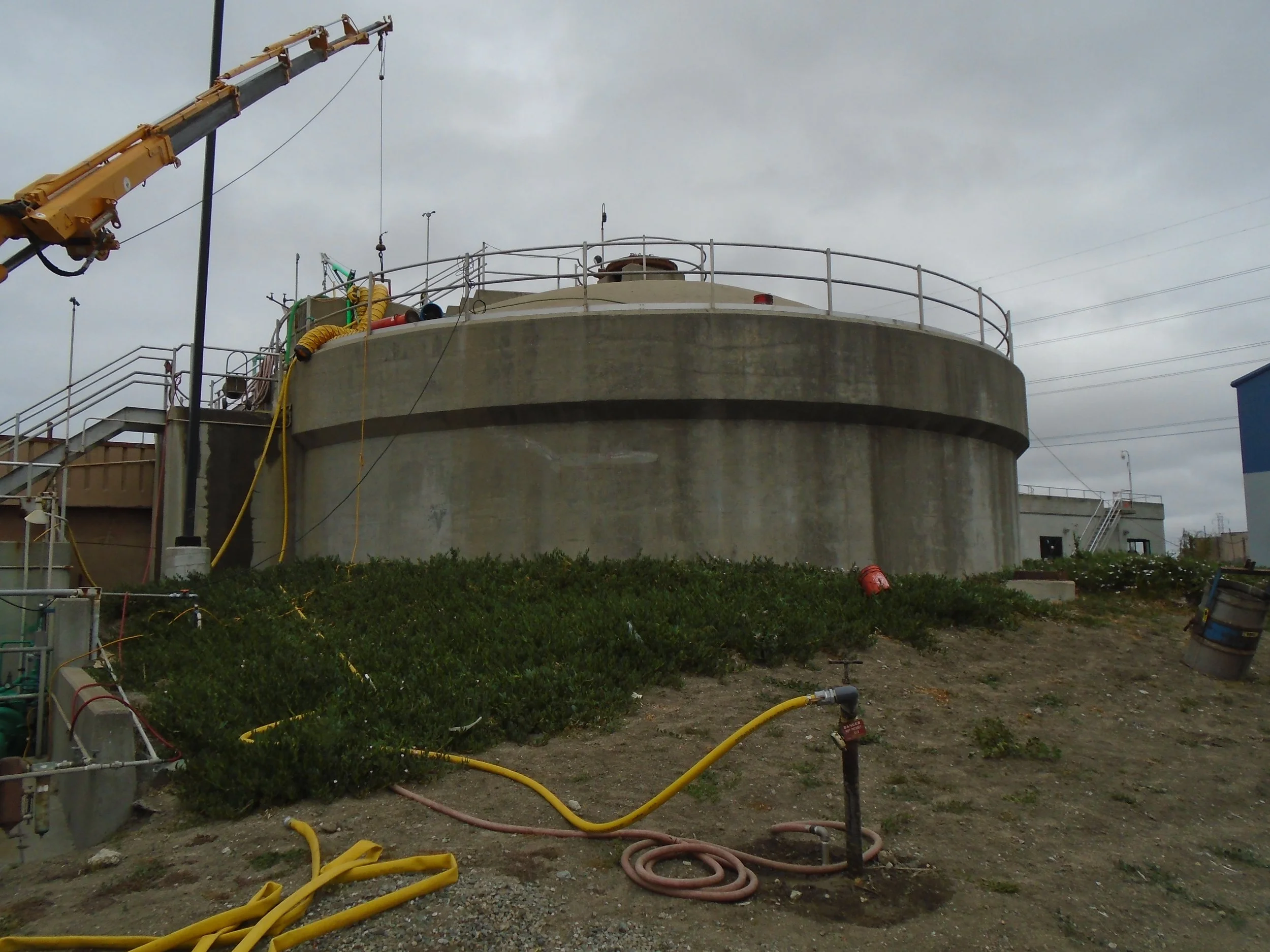 Exterior view of the Vacuator structure at a municipal sewage treatment plant, showing its cylindrical form and surrounding infrastructure.