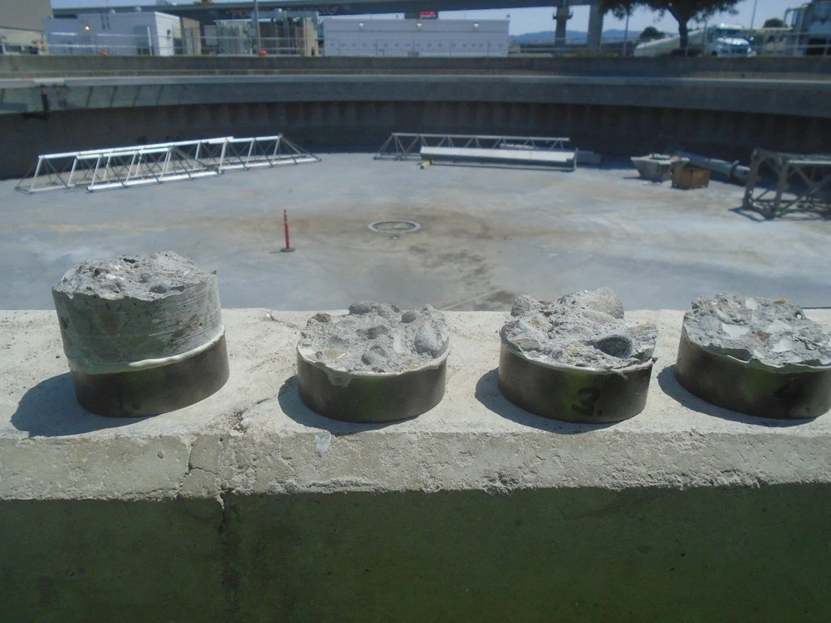 Multiple pull-off test core samples aligned to display and compare varying failure depths of concrete and mortar adhesion at the EBMUD clarifier