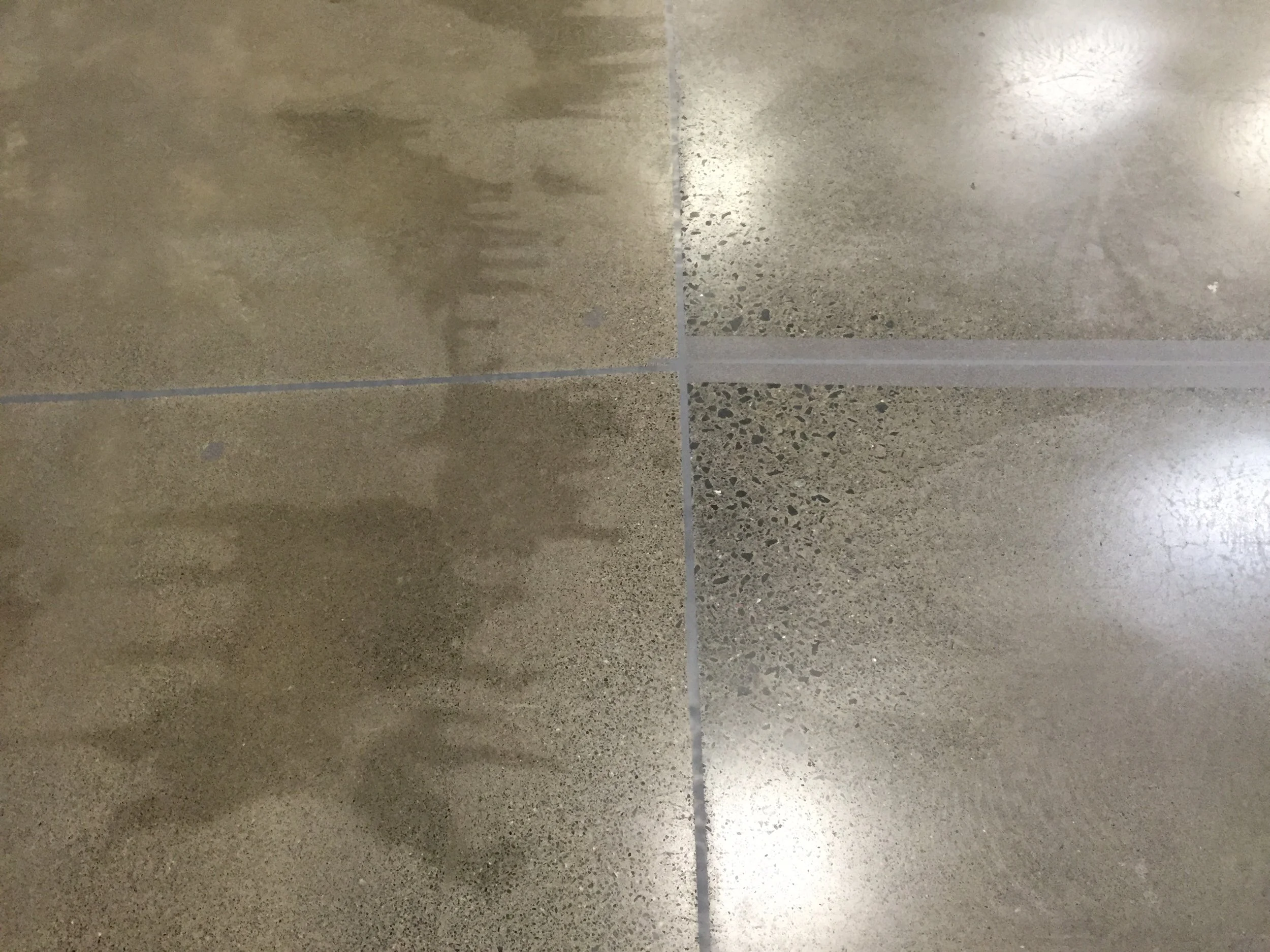 Repaired warehouse concrete slab with ground finish and renewed sealed joints.