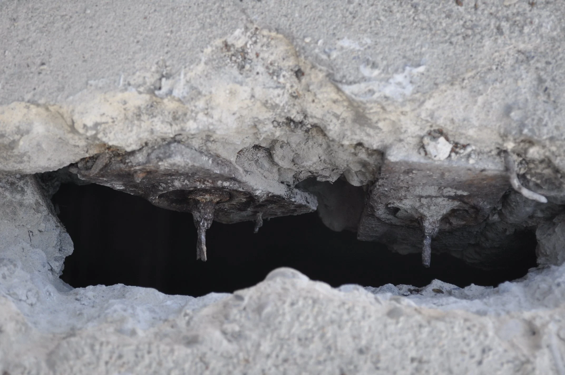 Deep spall revealing post-tension tendons