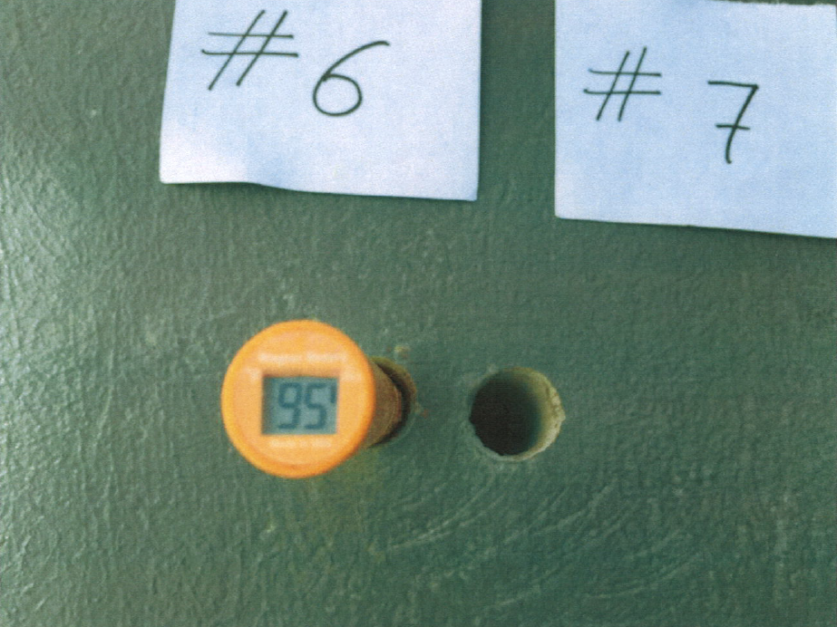 Digital RH meter at a slab test port reading 95 percent during in-slab humidity testing.