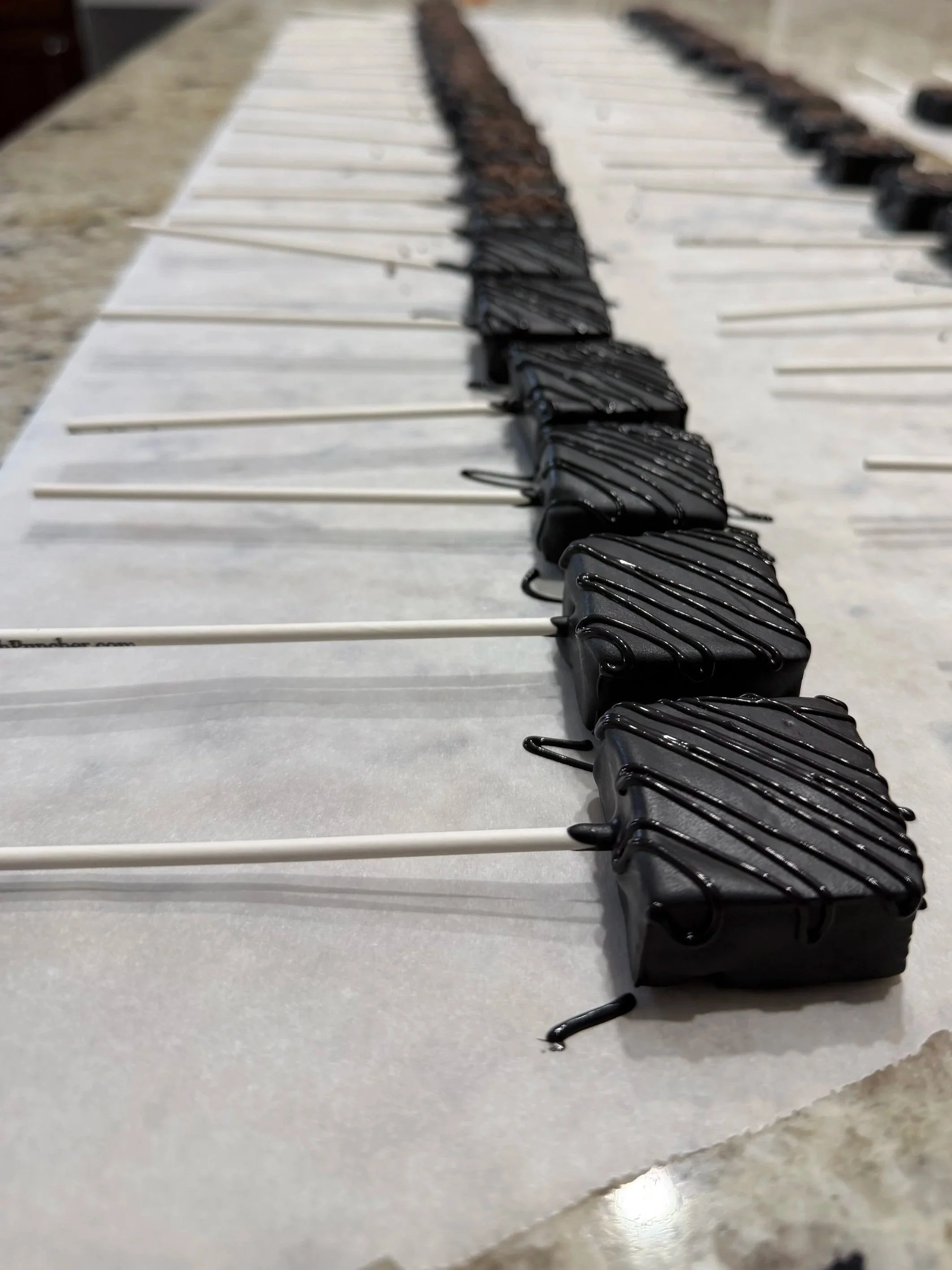 Black drizzled square cake pops