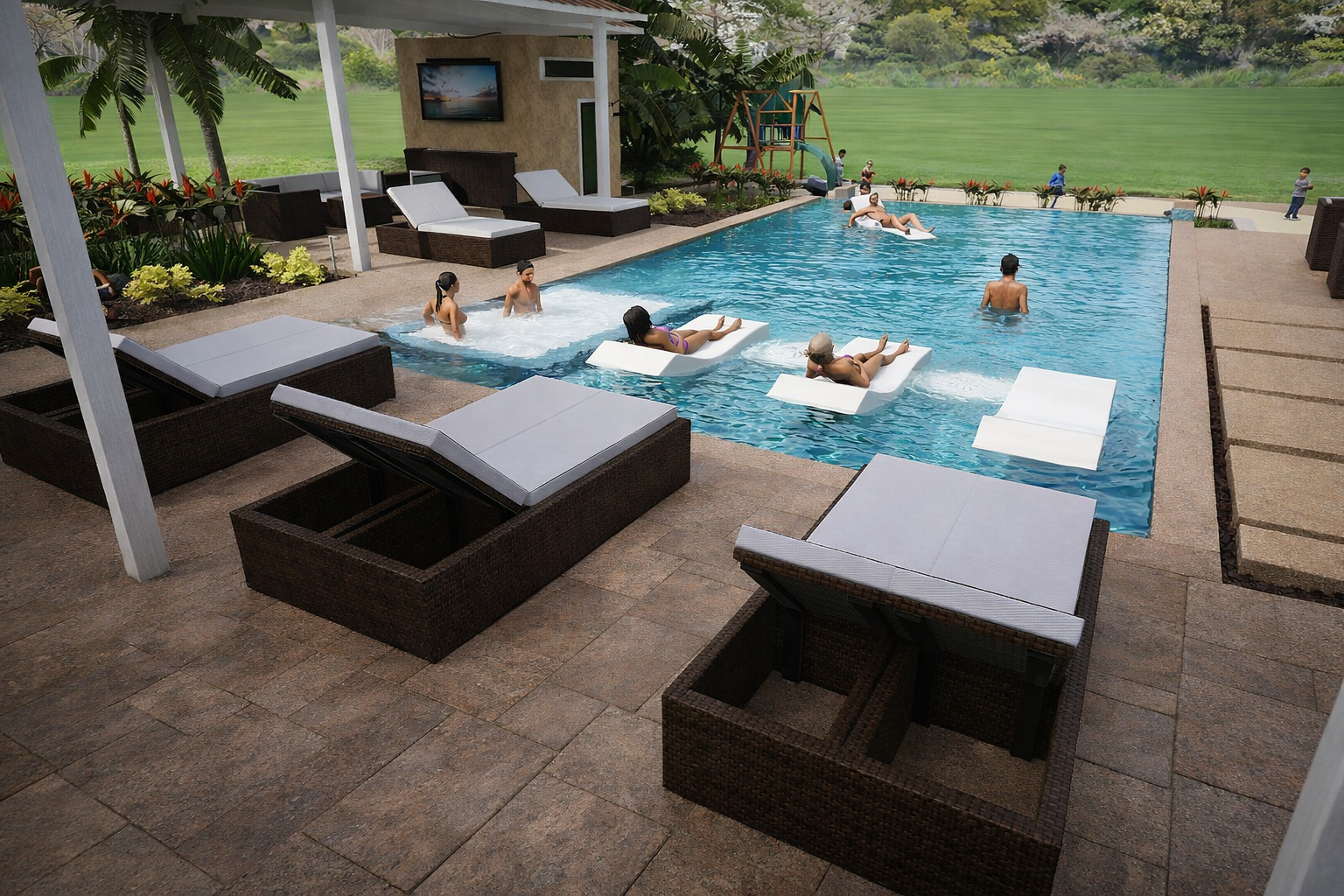 People relaxing and swimming in an outdoor swimming pool surrounded by lounge chairs, greenery, and a playground in the background.
