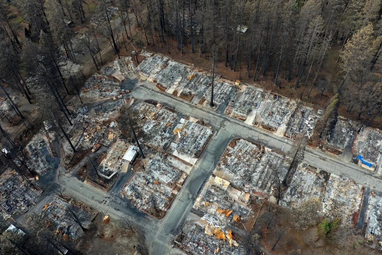 Aerial view of wildfire damage showing destroyed homes and burned vegetation following a major California wildfire.