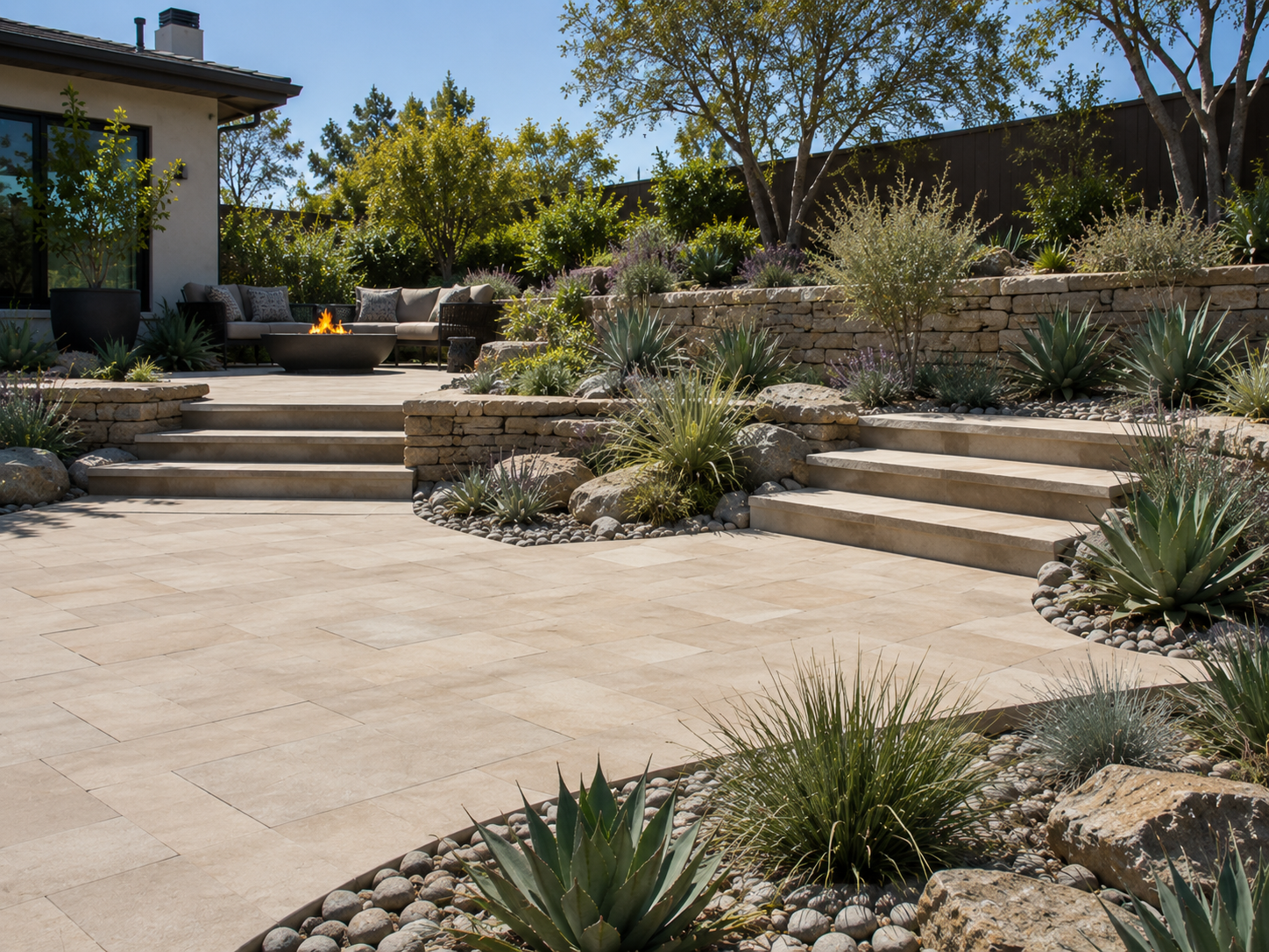 San Diego Zone 0 landscape conversion featuring a modern backyard patio with fire pit, outdoor seating, drought-tolerant plants, decorative rock, and landscape lighting designed for a fire-conscious California landscape.