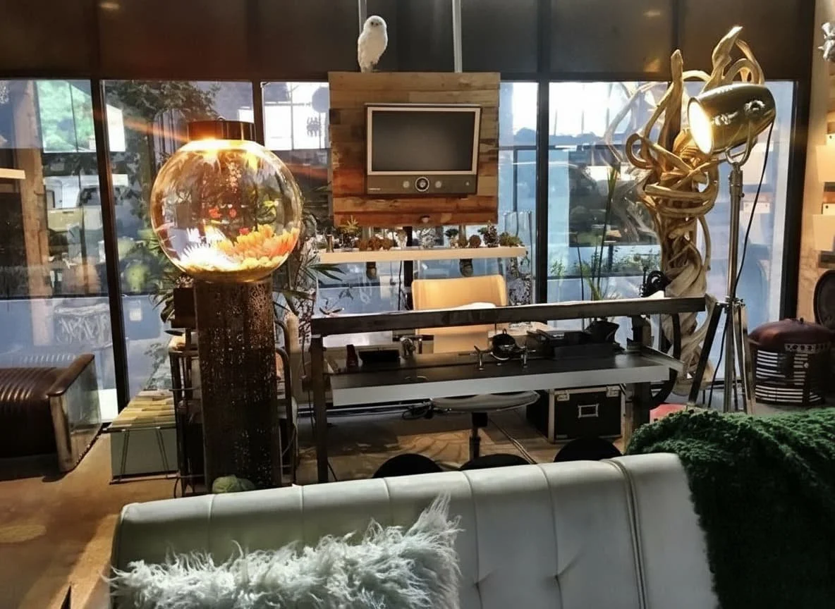 Interior of a modern room with large glass windows, a fish tank lamp, a small TV, a folding table with DJ equipment, a vintage tripod lamp, and various seating arrangements.