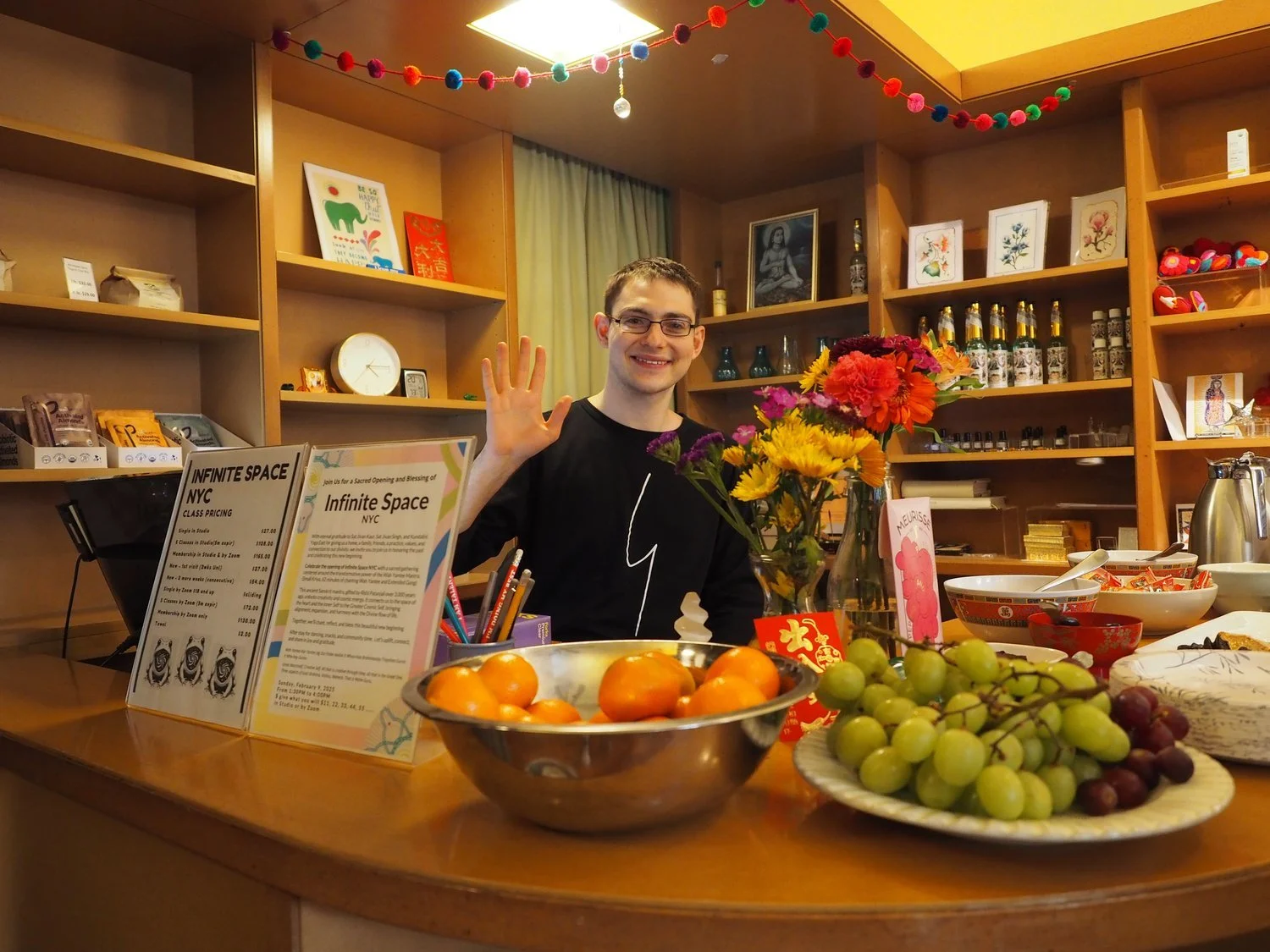 A photo of Ben behind the desk at Infinite Space with bowls of fruit on the counter.