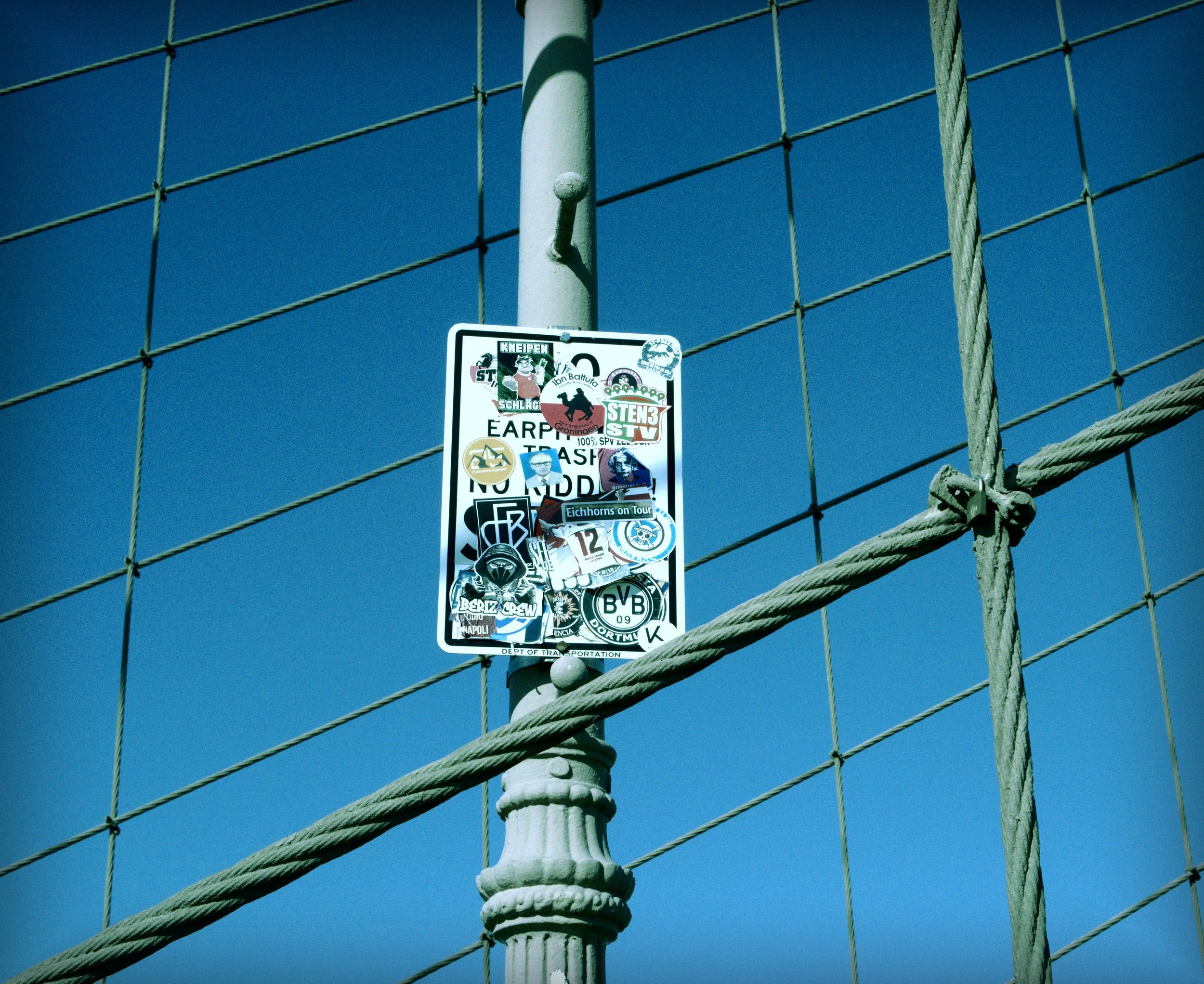 A DOT Sign full of Stickers and Logos on Brooklyn's Bridge