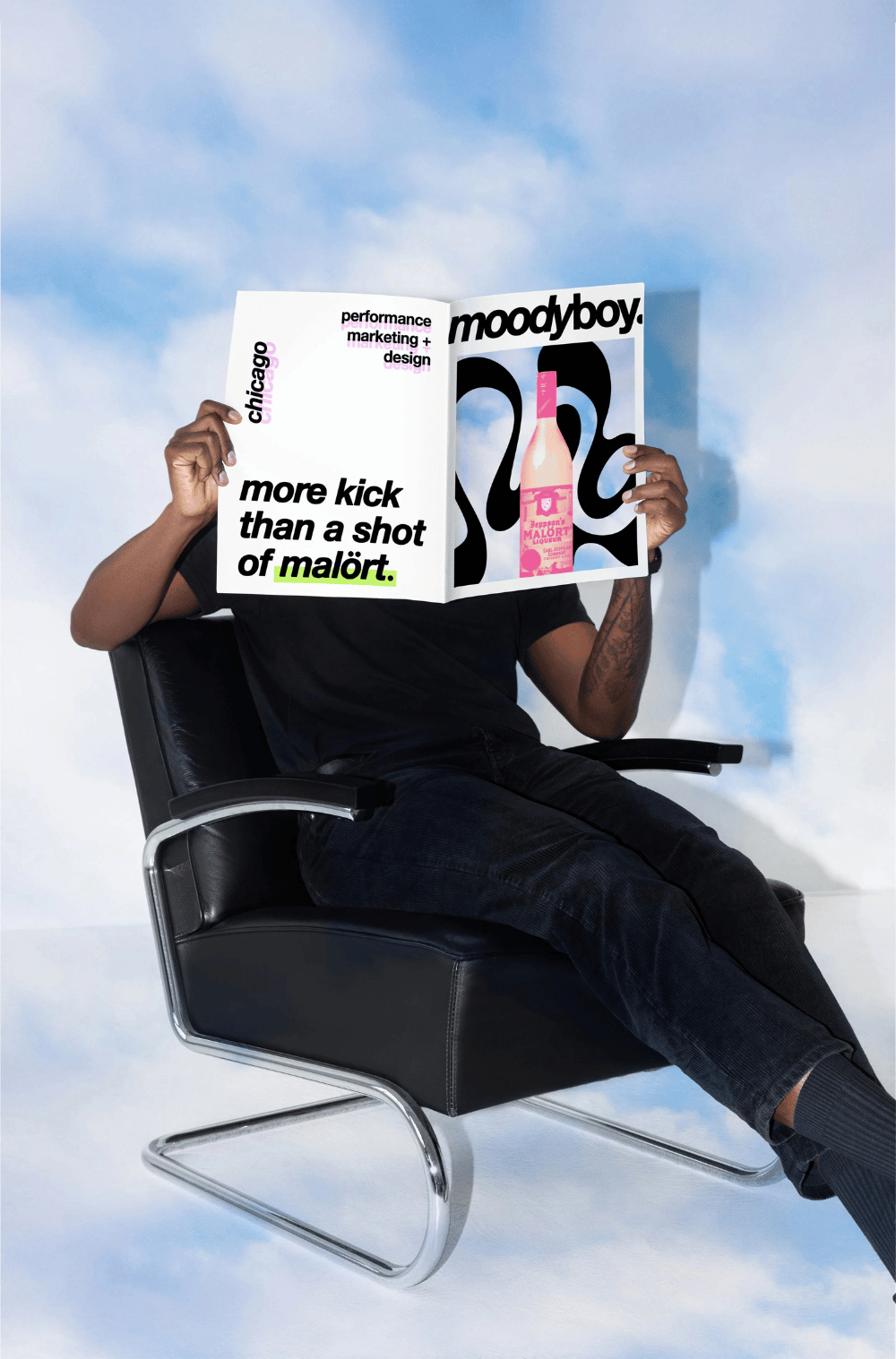 A man in a chair reading a magazine that says "more shot than a kick of malort."