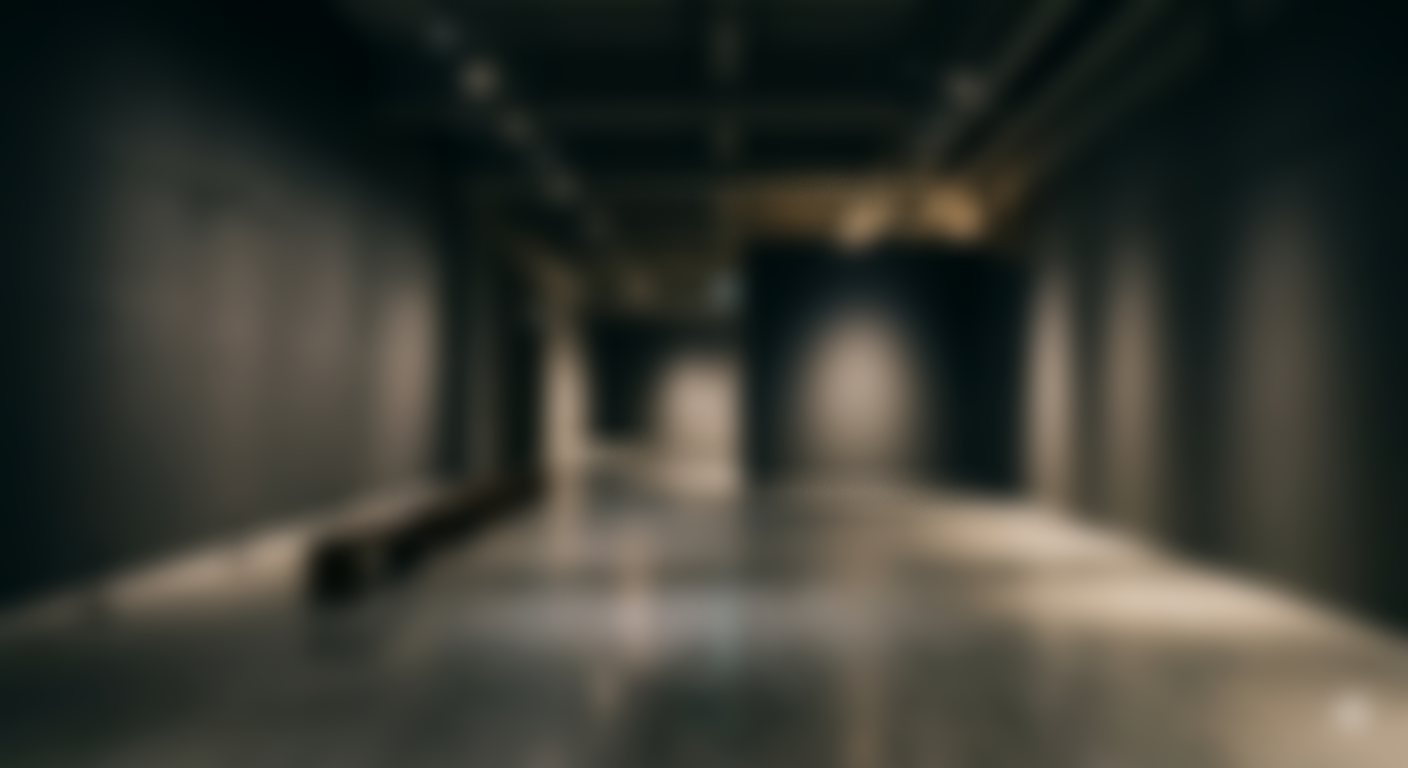 Blurred image of an empty corridor or hallway with dark walls and lighting.