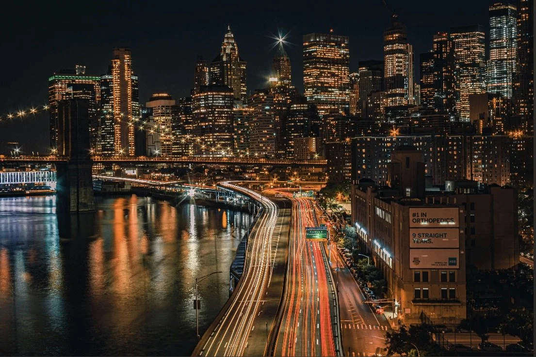 Long line of cars with glowing brake lights during rush hour in a city