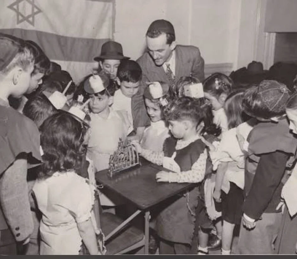 Jewish teacher instructing students in a traditional classroom setting with Hebrew texts