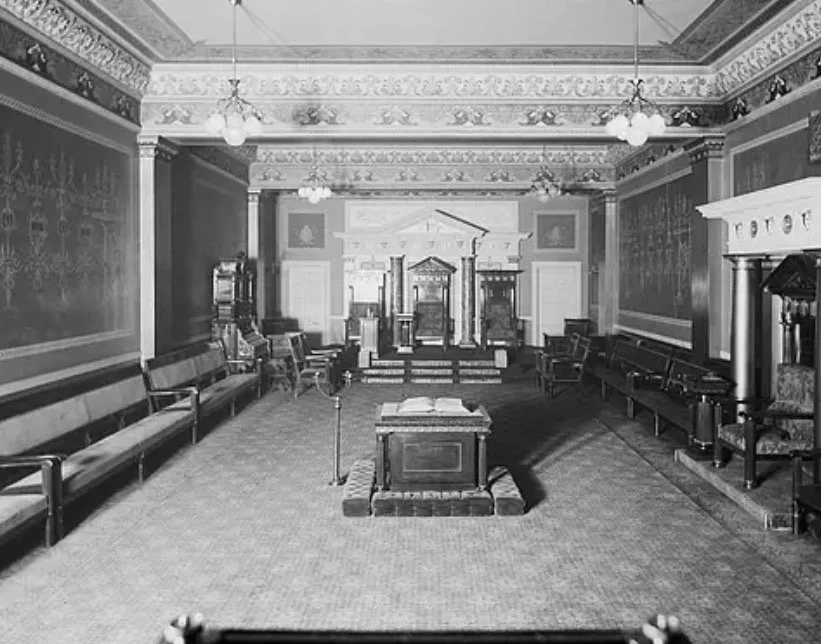 Interior of a traditional Masonic lodge room with chairs, altar, and symbolic furnishings typical of mid-century meetings.