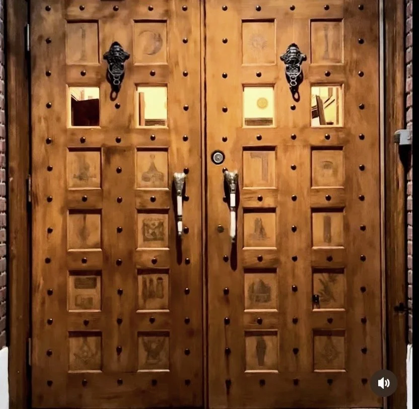 Custom wooden doors with engraved Masonic symbols at Advance Masonic Temple entrance