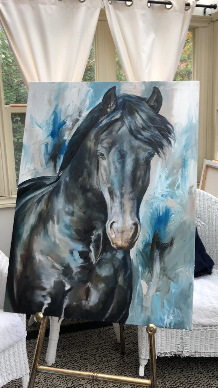 A portrait painting of a black horse with a grayish face, detailed with a background of white, blue, and gray brushstrokes, set up on an easel inside a room with white curtains and windows showing greenery outside.