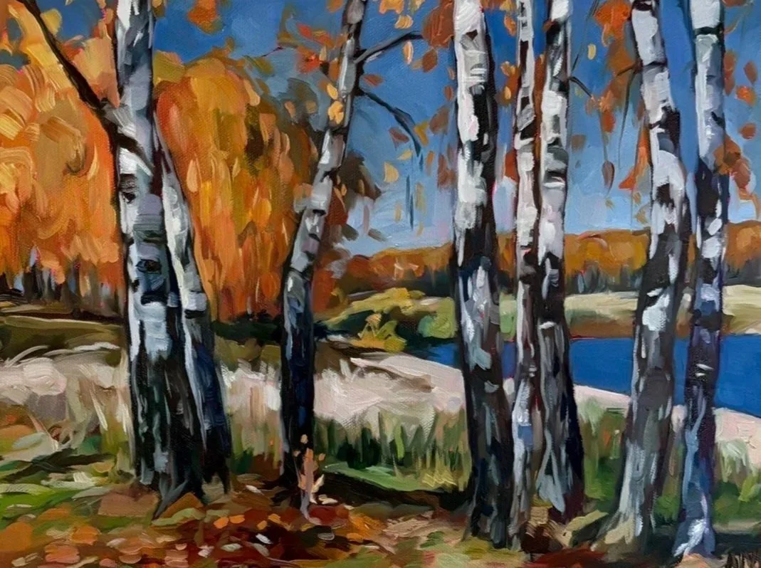 An impressionist painting of a landscape with orange and yellow trees, a blue sky, and a river or pond.