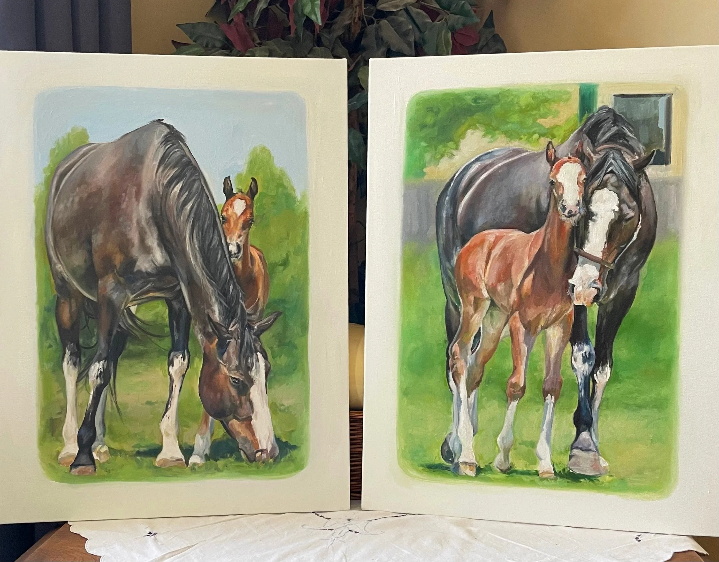 Two paintings of horses with foals in a green outdoor setting. The left painting shows a dark brown horse with a foal next to it, both with white markings on their legs and faces. The right painting features a similar scene with a dark horse and a foal, both with white markings, in front of a fence and trees.