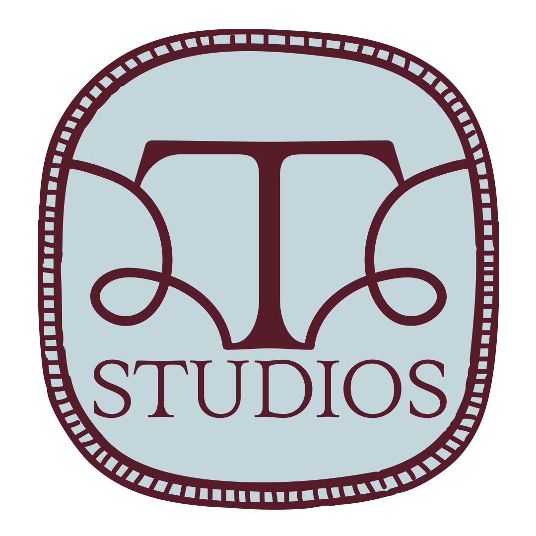 Logo for 2TWO2 Studios featuring an elegant letter T intertwined with decorative 2 flourishes inside a rounded square with a dotted border.