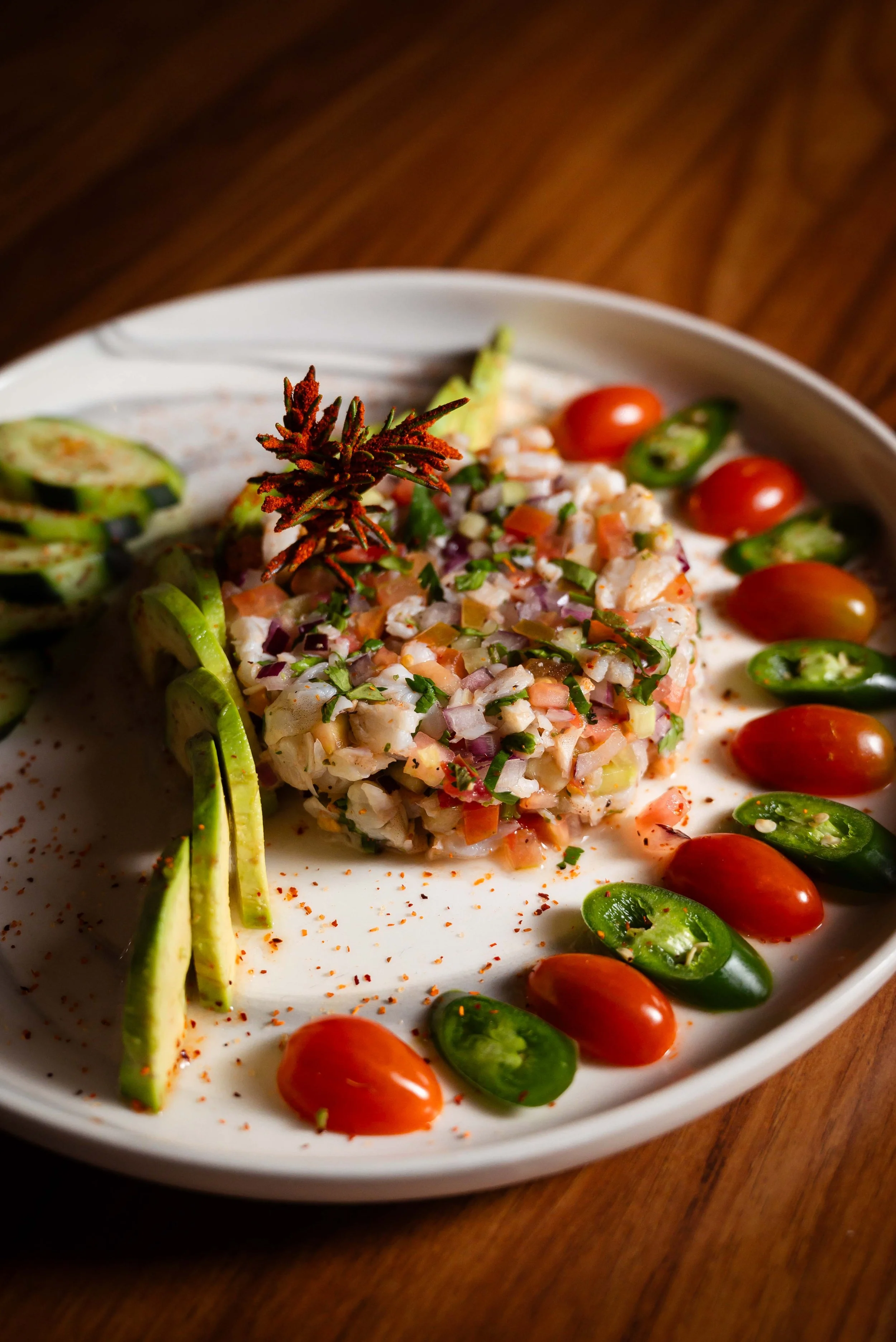Platillo de ceviche de camarón acompañado con pepino, aguacate y chiles.