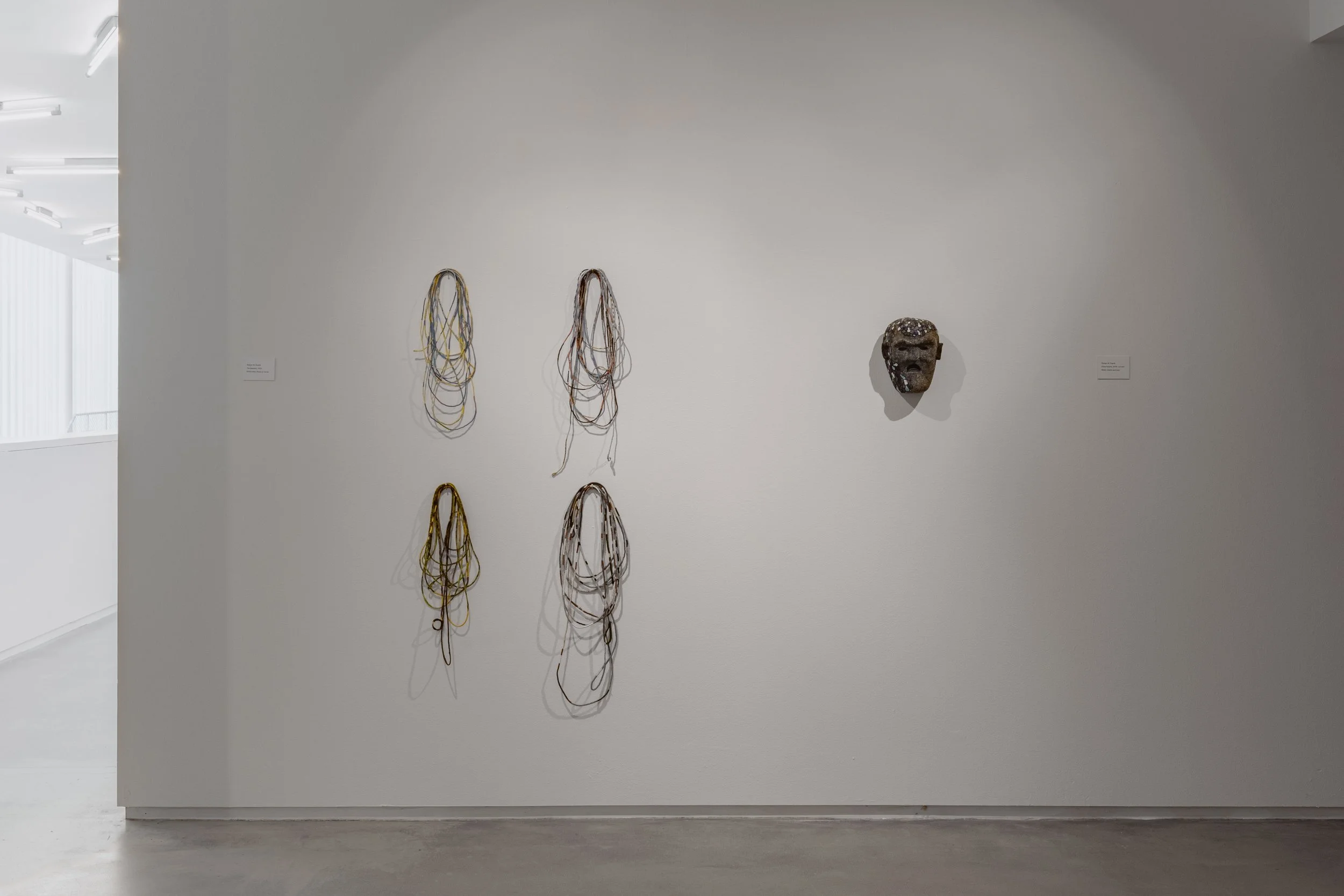 (Left) Time keepers. Embroidery floss on twine; each 30 ft long; 2024-25.

(Right) Mask, no.8. Glass beads and wax on wood; 9 in x 8 in x 5 in: 2019.