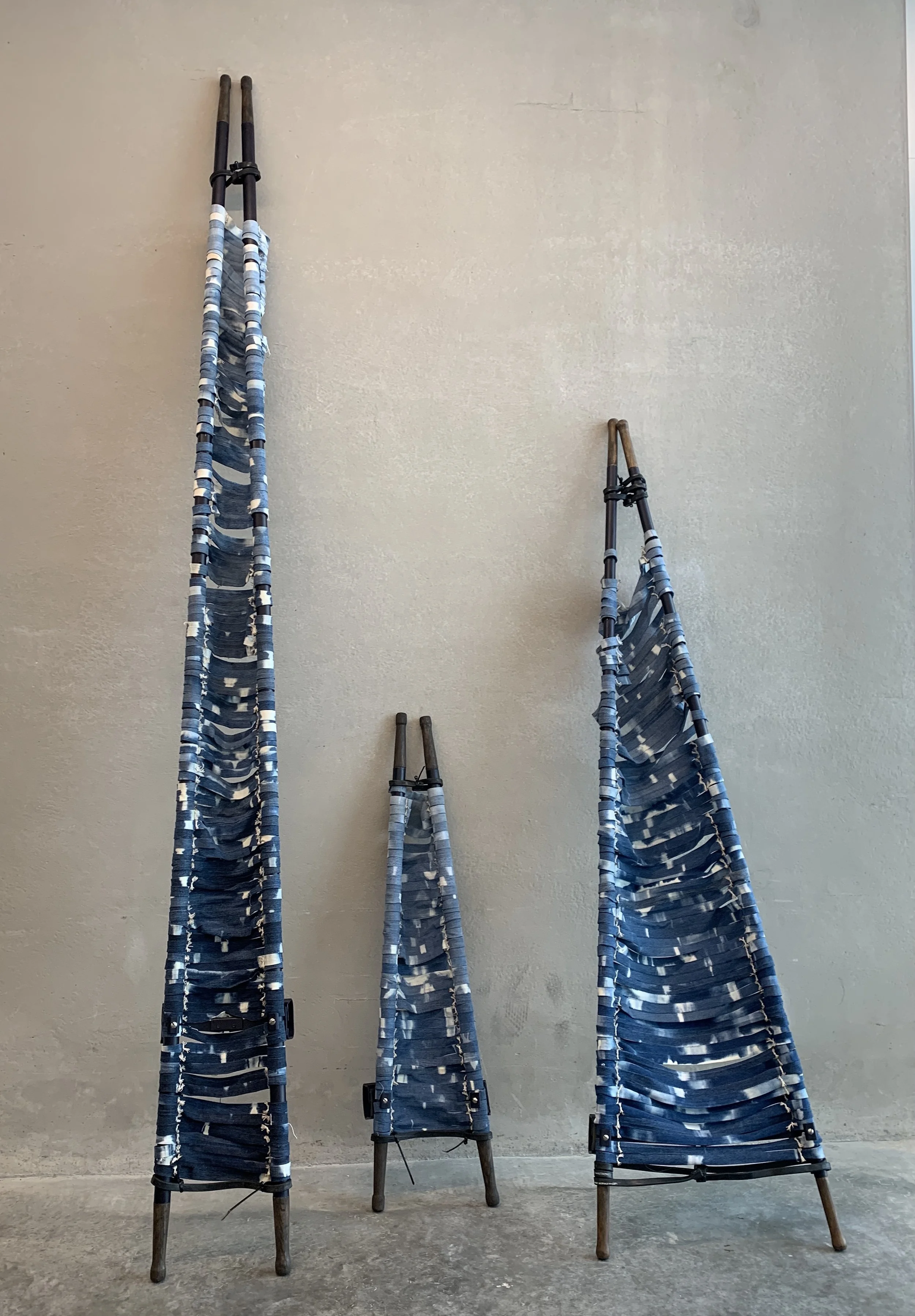 Thoughts and Prayers. Bleached denim, US military field stretchers, rubber. 8 ft x 18 ft x 3 ft; 2020.