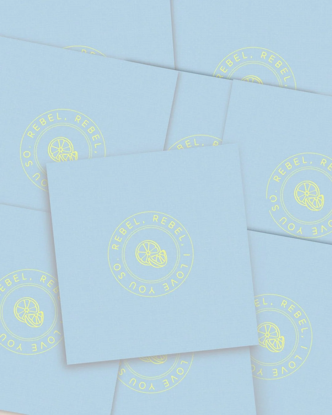Pile of baby blue business cards with yellow logo designed by Aamu, the best branding desginer in Bend Oregon.
