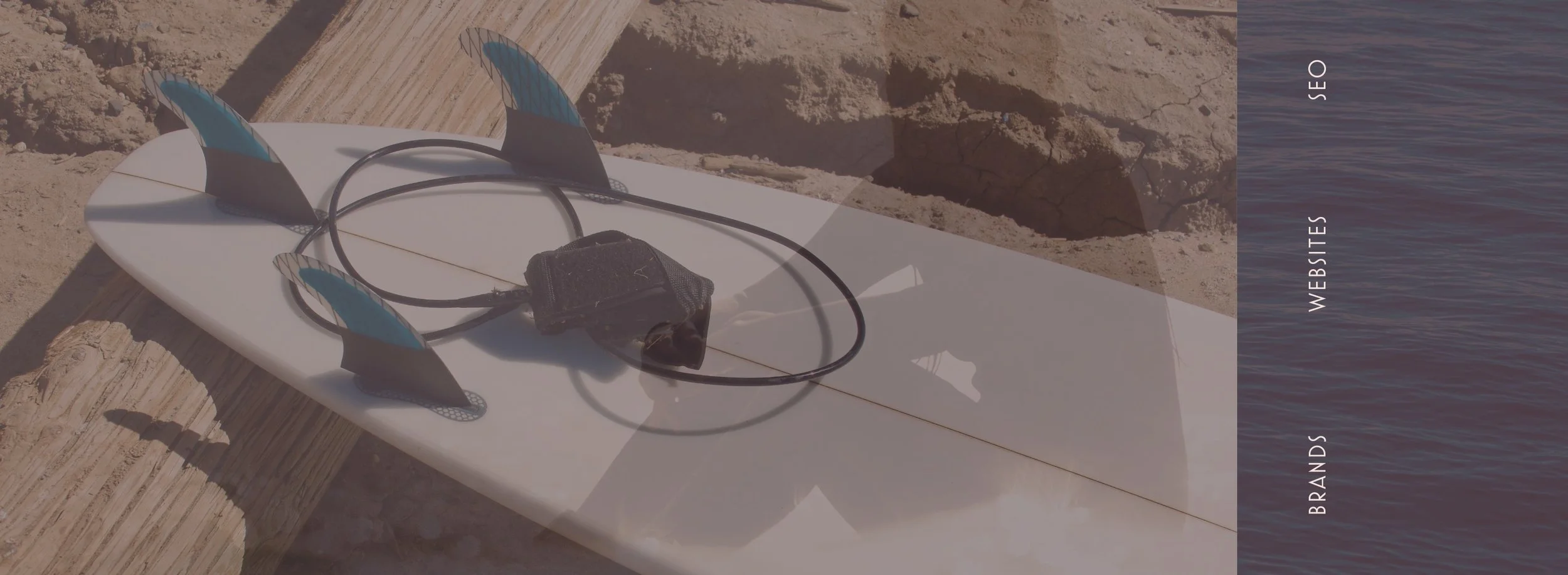 A surfboard and a leash on a log. It's part of the feeling of website branding of Aamu Creatives Studio in Bend Oregon. 