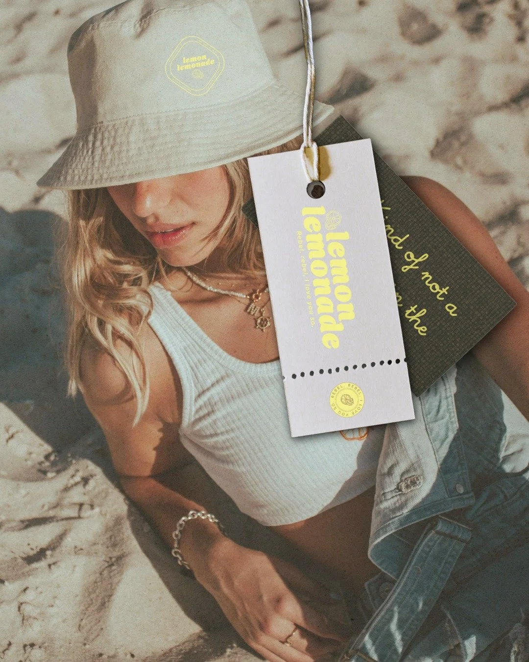 A girl on sand wearing a bucket hat with label designs made by Aamu Creative Branding designer in Bend Oregon.