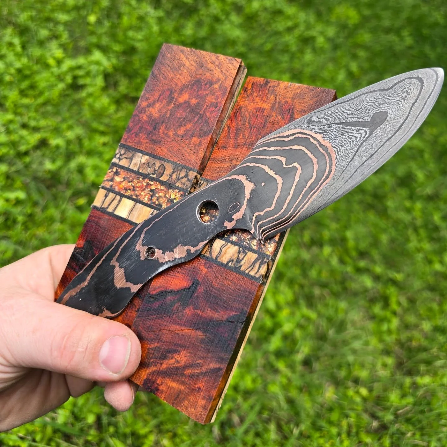 Epic blade needs some epic scales! This multi-layered carbon steel and copper damascus is getting paired with dragons blood amboyna Burl, spalted maple segments and bottom liner with a center segment made from copper leaf cast in resin. Excited to se