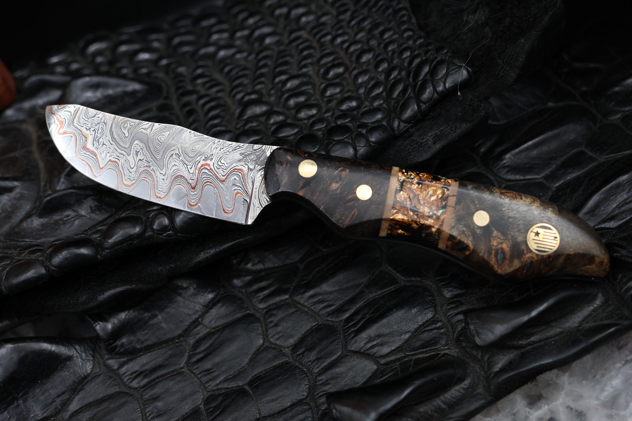 One of the most talked-about knives at our last show.

It's easy to see why.

The blade features a checkerboard Damascus core with copper and nickel shims, wrapped in stunning Chaos Damascus cladding. The billet itself was forged by Adam Deville Dama