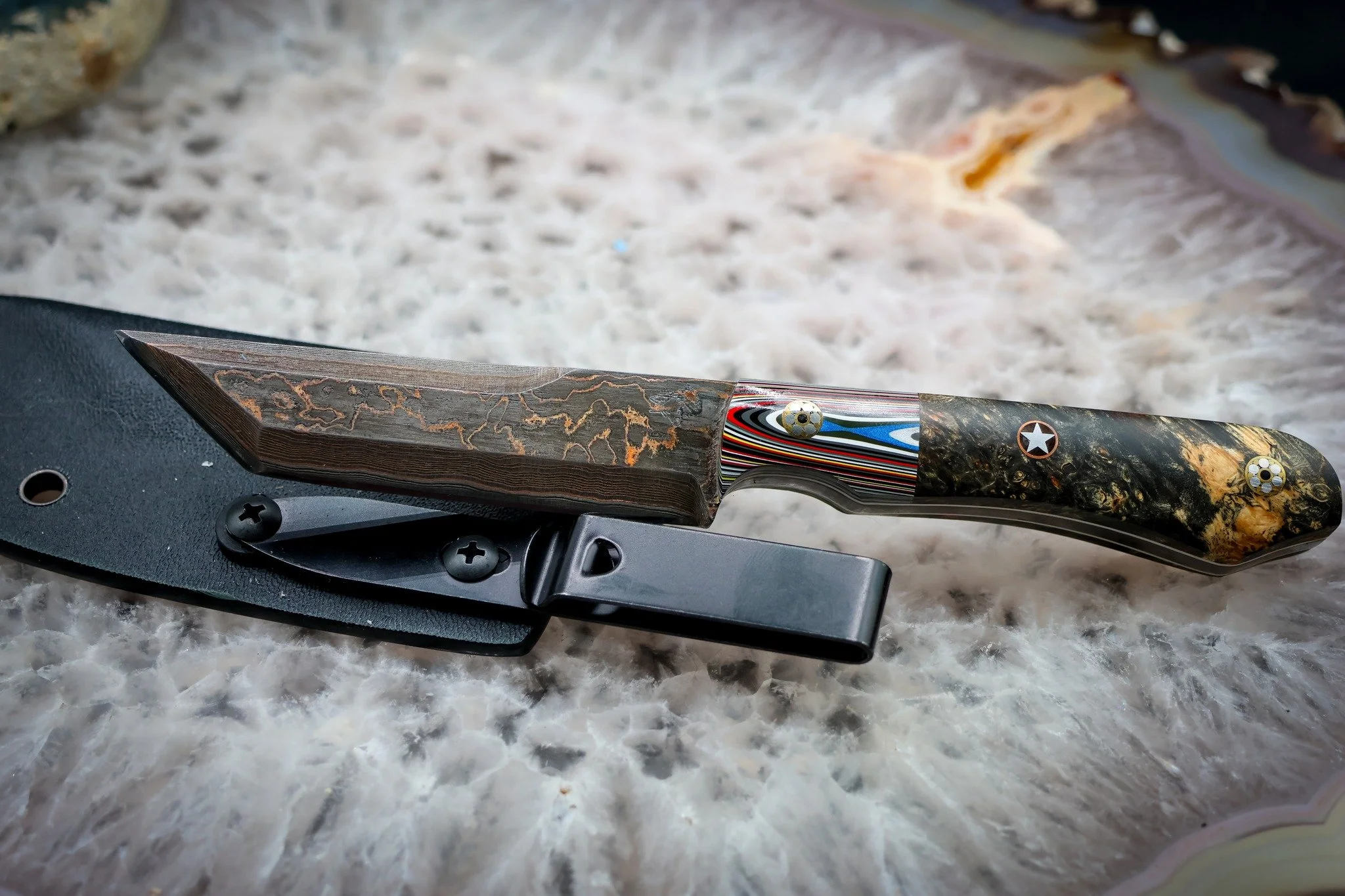 A little Jeep history hiding in the handle. 👀

This piece combines Jeep Fordite and buckeye with mosaic pins and a Texas star pin, paired with layered 1080 and copper Damascus.

If you've never seen Fordite before, those colorful stripes aren't pain