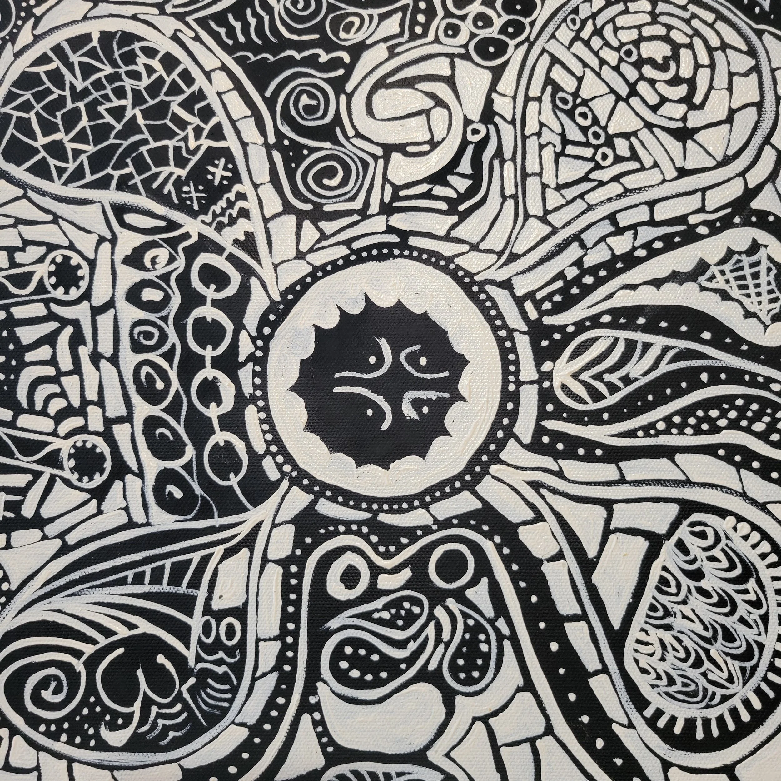 Black and white tribal-style abstract design with various patterns, swirls, and shapes including a central sun-like shape with a face, surrounded by intricate geometric and organic motifs.