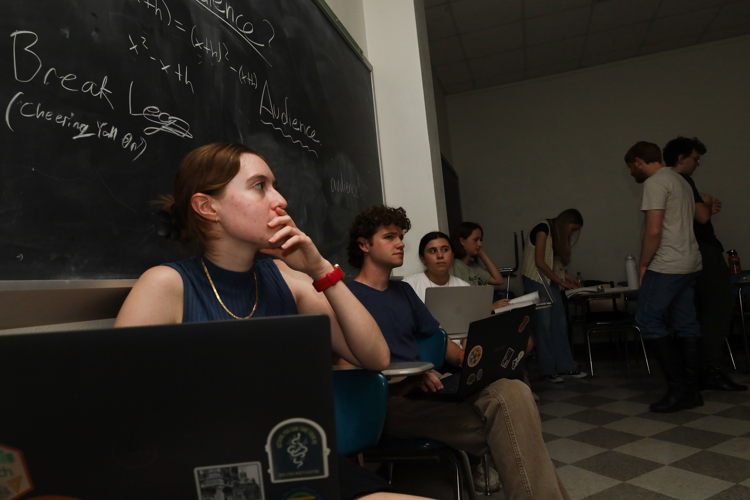 Left to right, Assistant Director Katelyn McIntyre, Director Preston Phillips and Choreographer Anna Blanchard sit on desks as they watch a scene run through on Oct. 15 at Parlin Hall. 