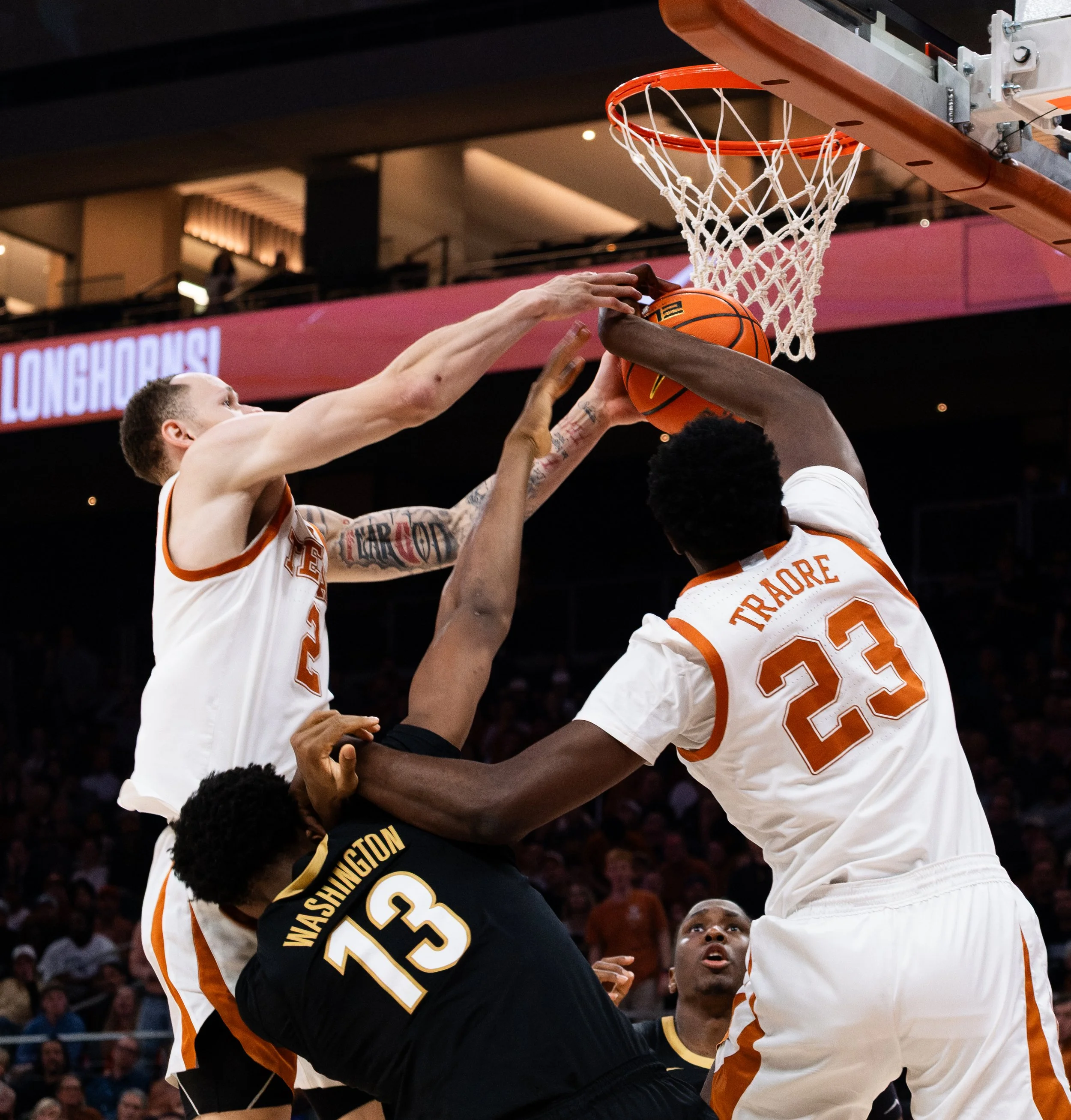 Texas' Chendall Weaver (left), Lassina Traore (right) and Vanderbilt's Jalen Washington (middle) fight for possession of the ball on Jan. 14, 2026.