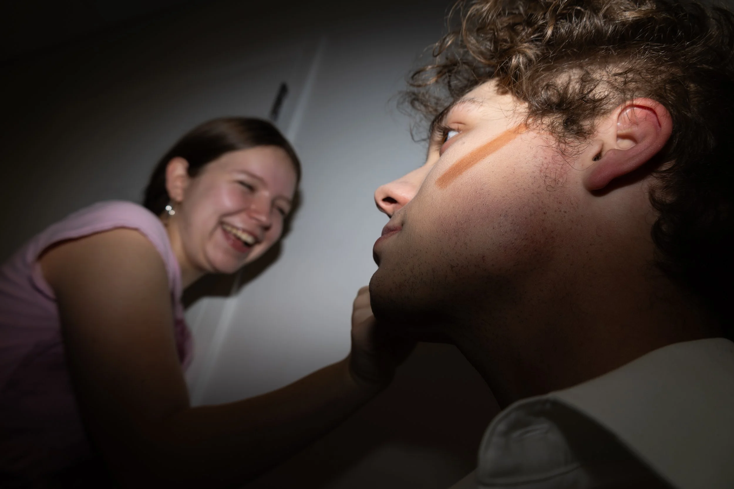 A member of the show's makeup crew applies makeup to ensemble member Jakob Wayson in the boys' dressing room on Oct. 30. 