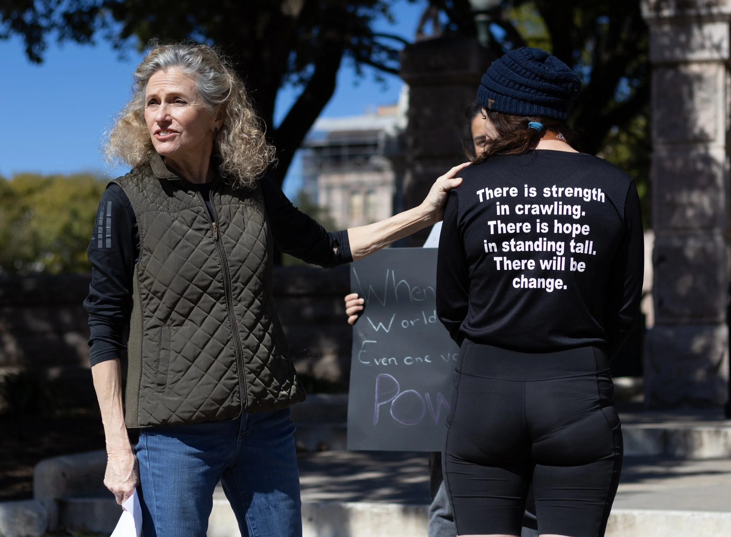 State Representative Donna Howard (D-Austin) reads message on the back of Summer Willis' shirt to crowd at a press conference in front of the Capitol on Feb. 16, 2025. Summer Willis crawled the first half of the Austin Marathon and ran the second hal