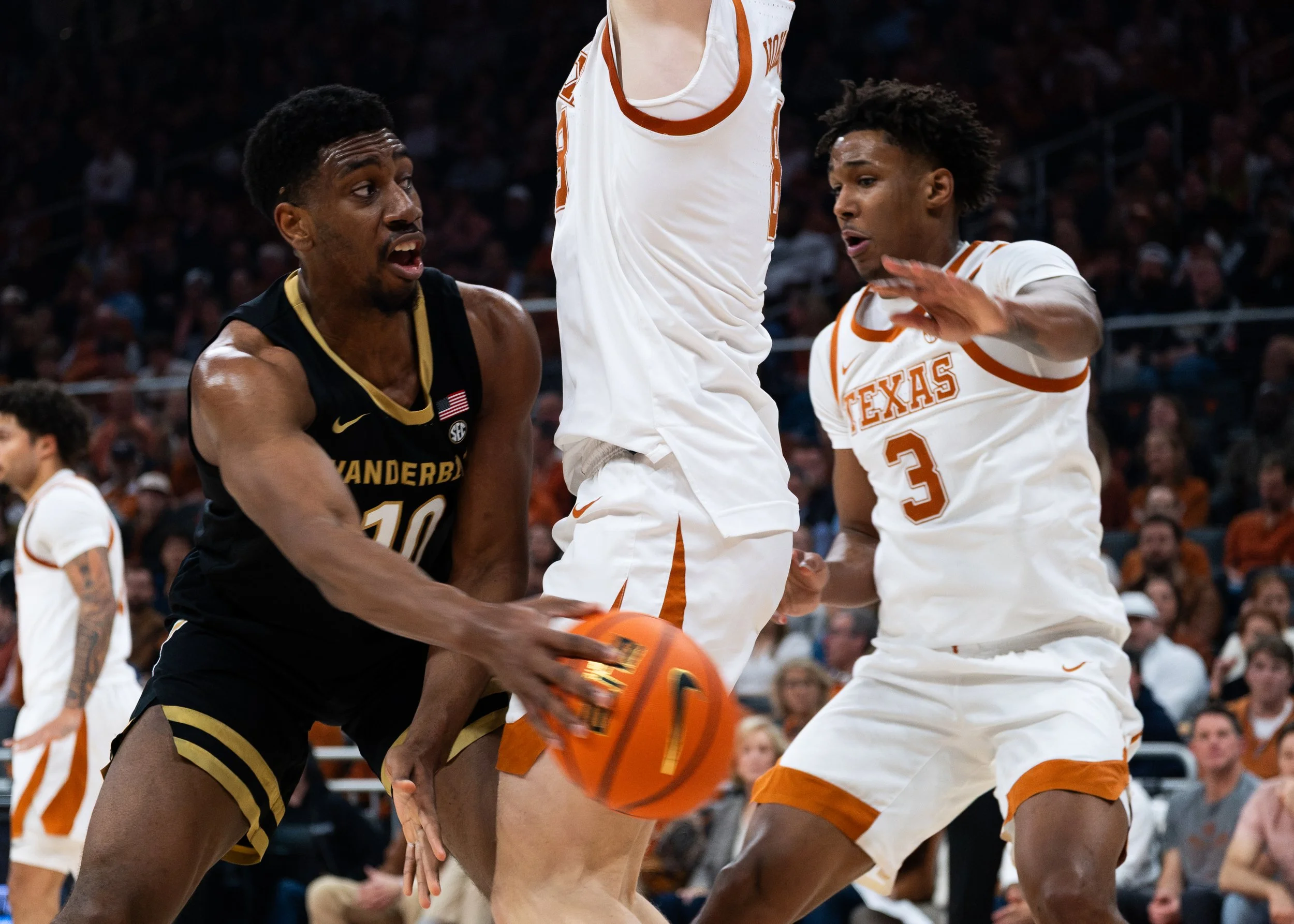 Texas' Dailyn Swain (right) and Matas Vokietatis (middle) guard Vanderbilt's AK Okereke on Jan. 14, 2026.