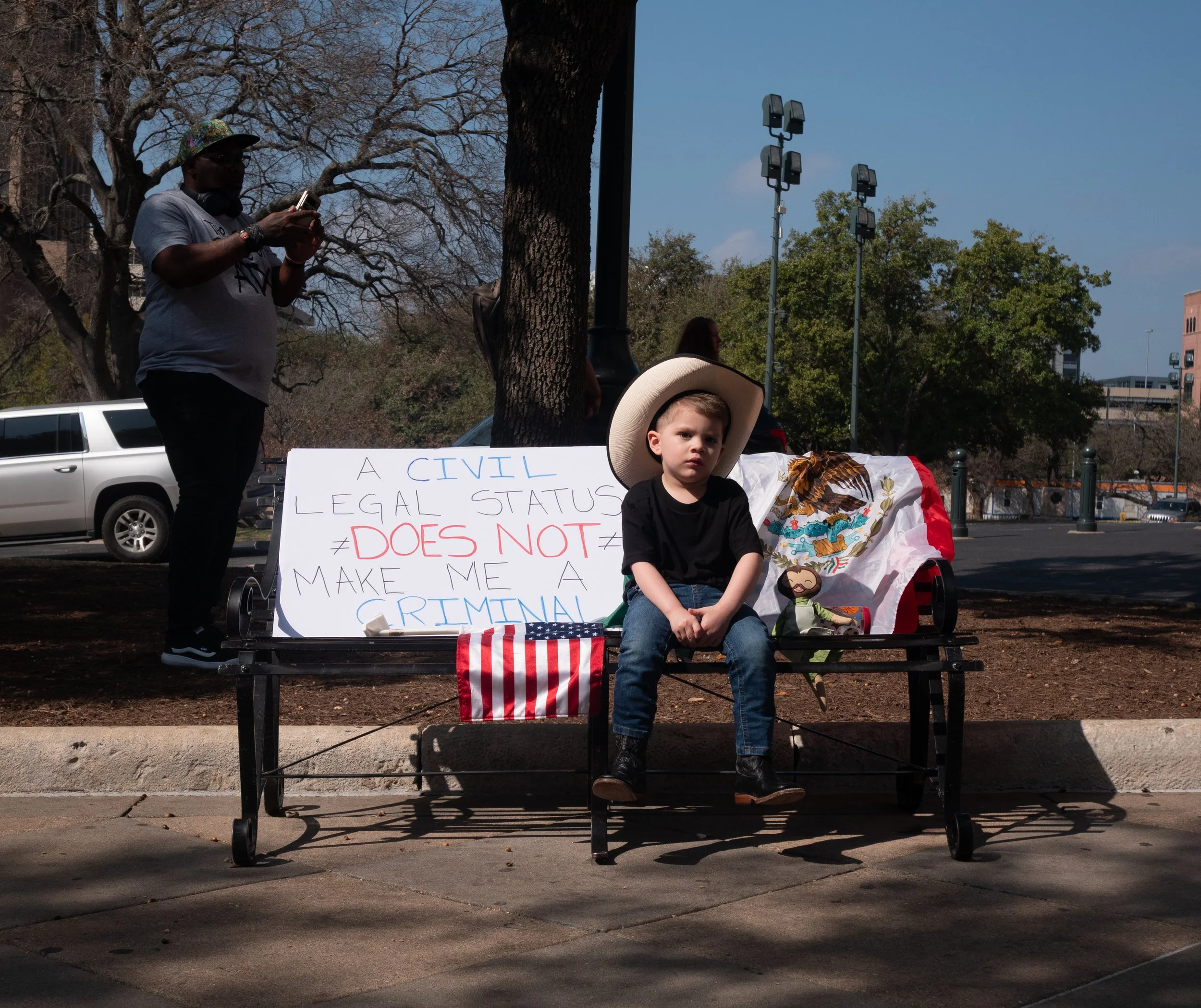 3-year-old Santiago sits on bench in front of the Capitol during immigration protest held by fraternity Sigma Lambda Beta on Feb. 8, 2025.
