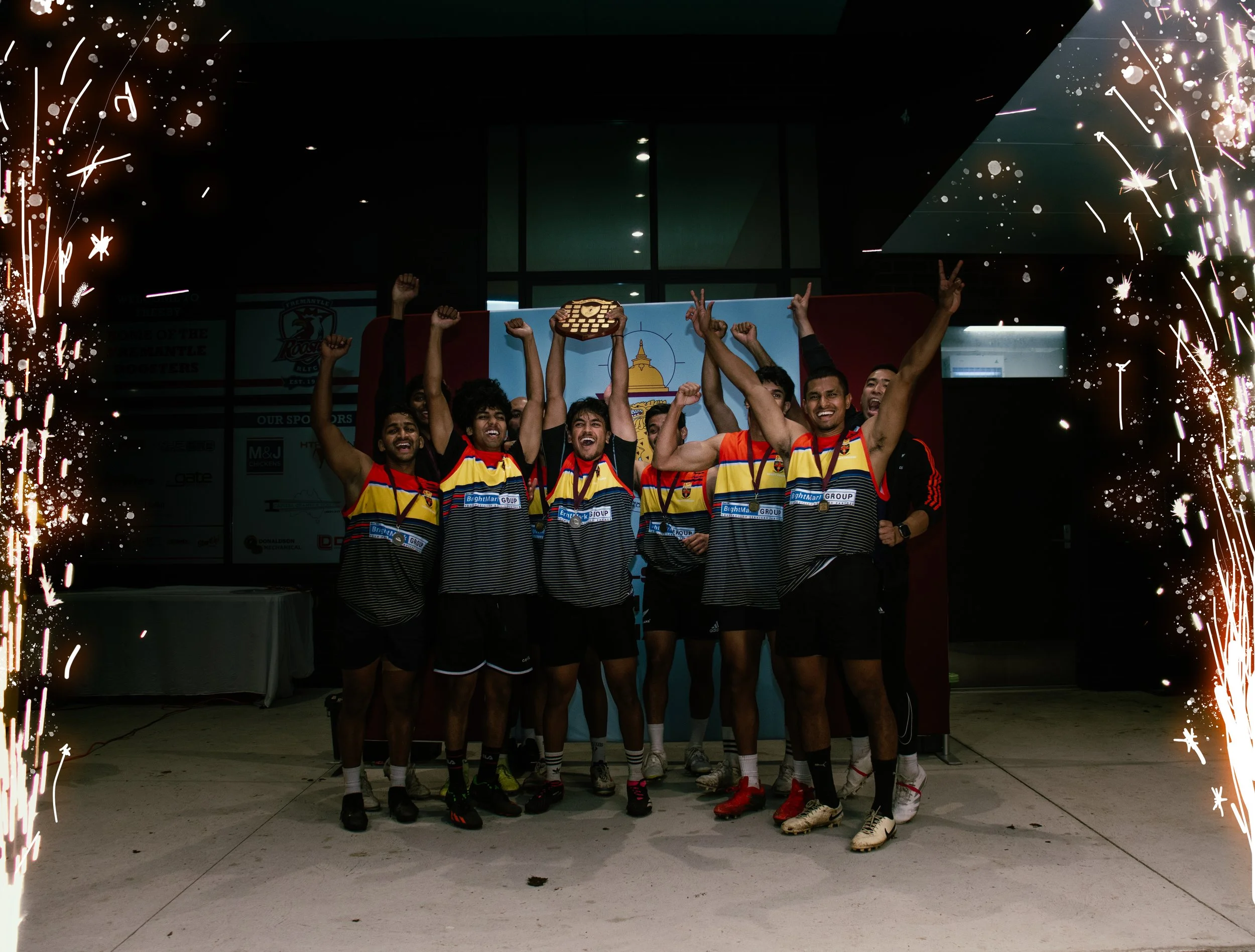 Group of young athletes celebrating with trophies, smiling, with fireworks border.