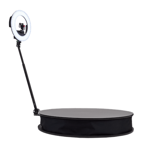 A ring light with a mounted camera on a tripod, positioned above a black circular platform.