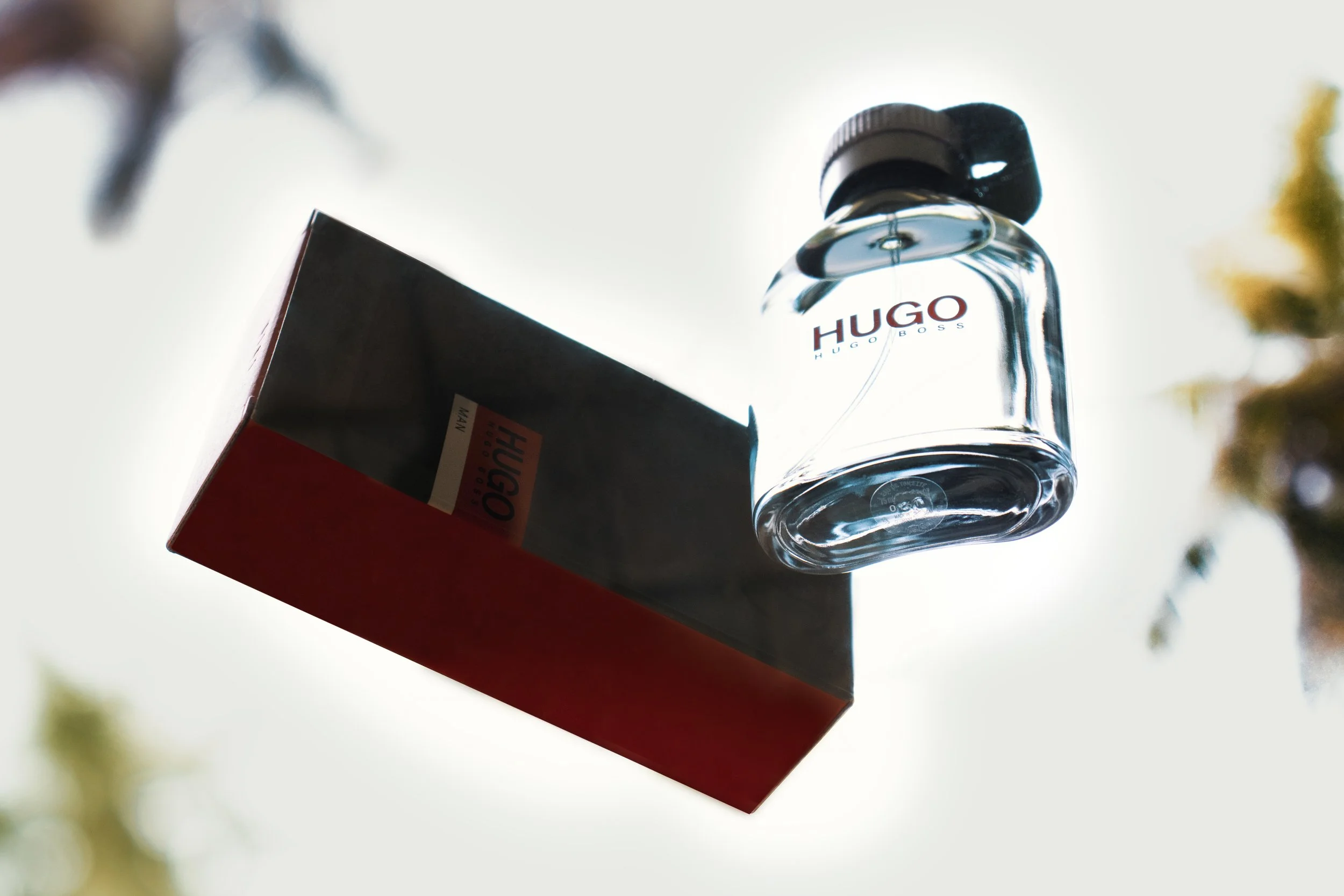 A Hugo Boss perfume bottle and its box are seen against a bright sky background.