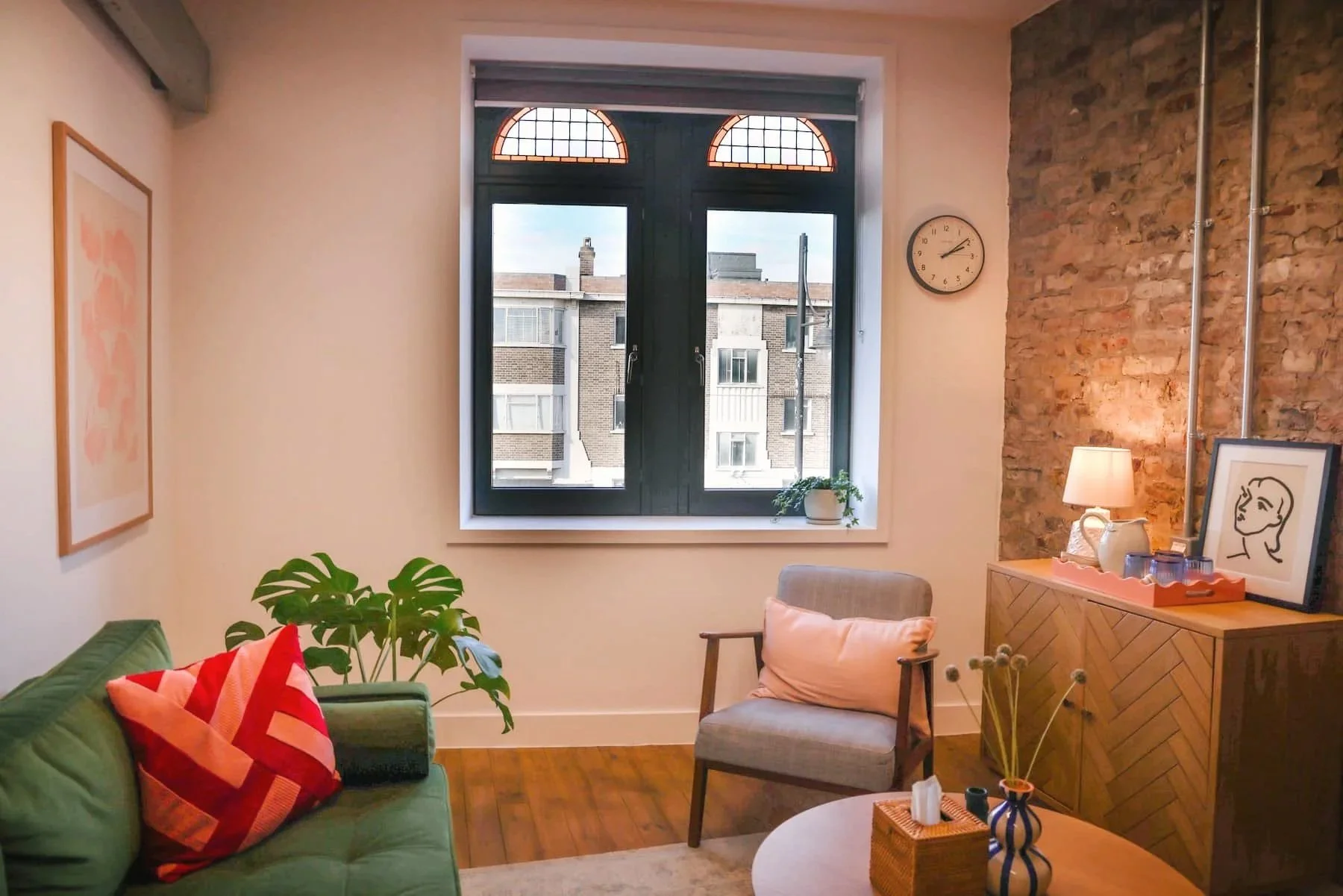 Warm therapy room interior, with comfortable sofa, chair and exposed brickwork in Brixton, South London