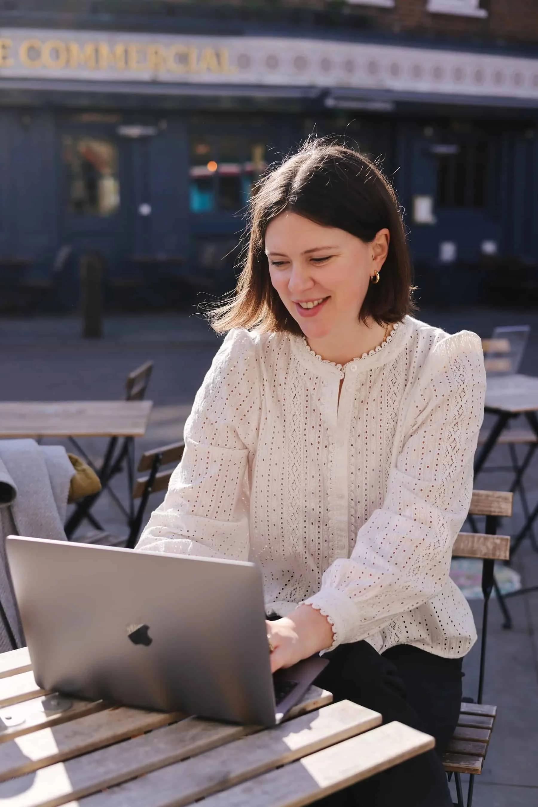 Dr Claire Buky-Webster working on a laptop outside in South London, clinical psychologist offering private therapy.