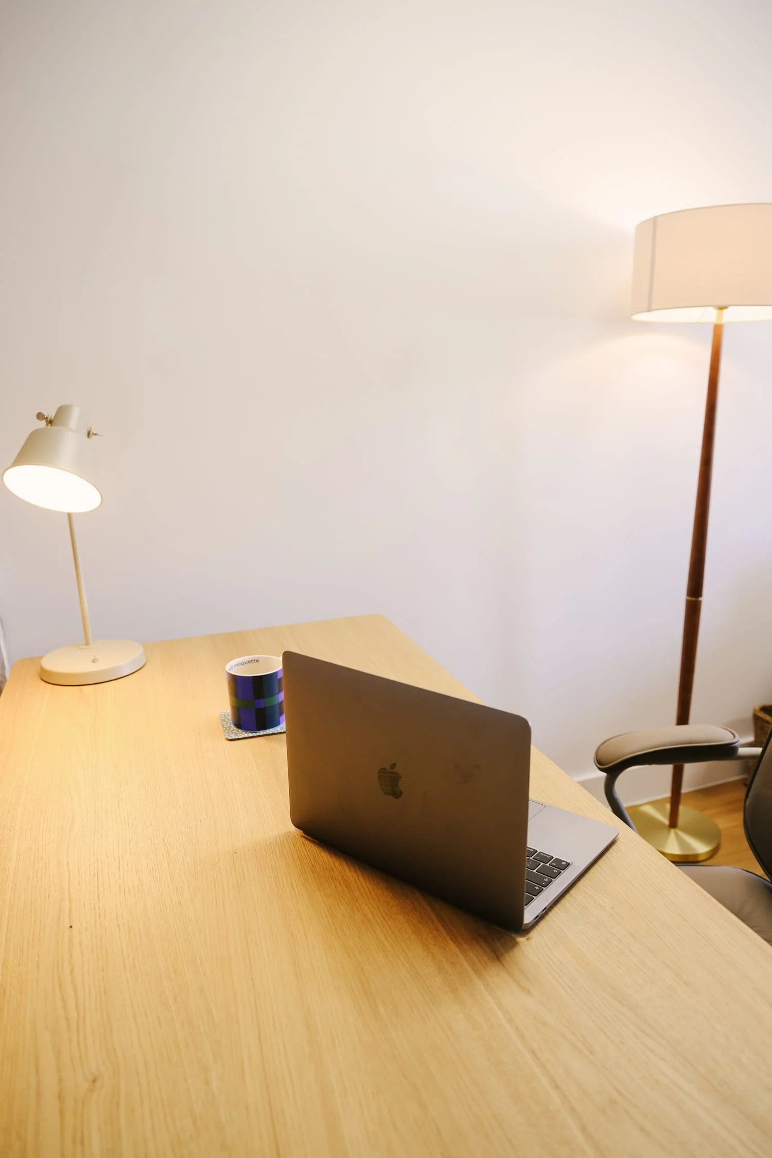 Desk workspace with laptop and lamp in private consulting room for associates in Brixton, South London