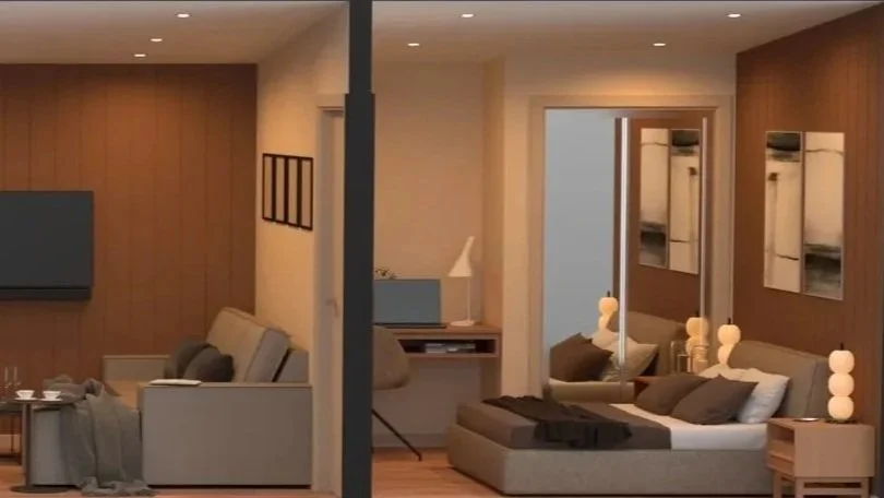 Living room divided into two sections with modern decor, a flat-screen TV, couches, lamps, and framed artwork.