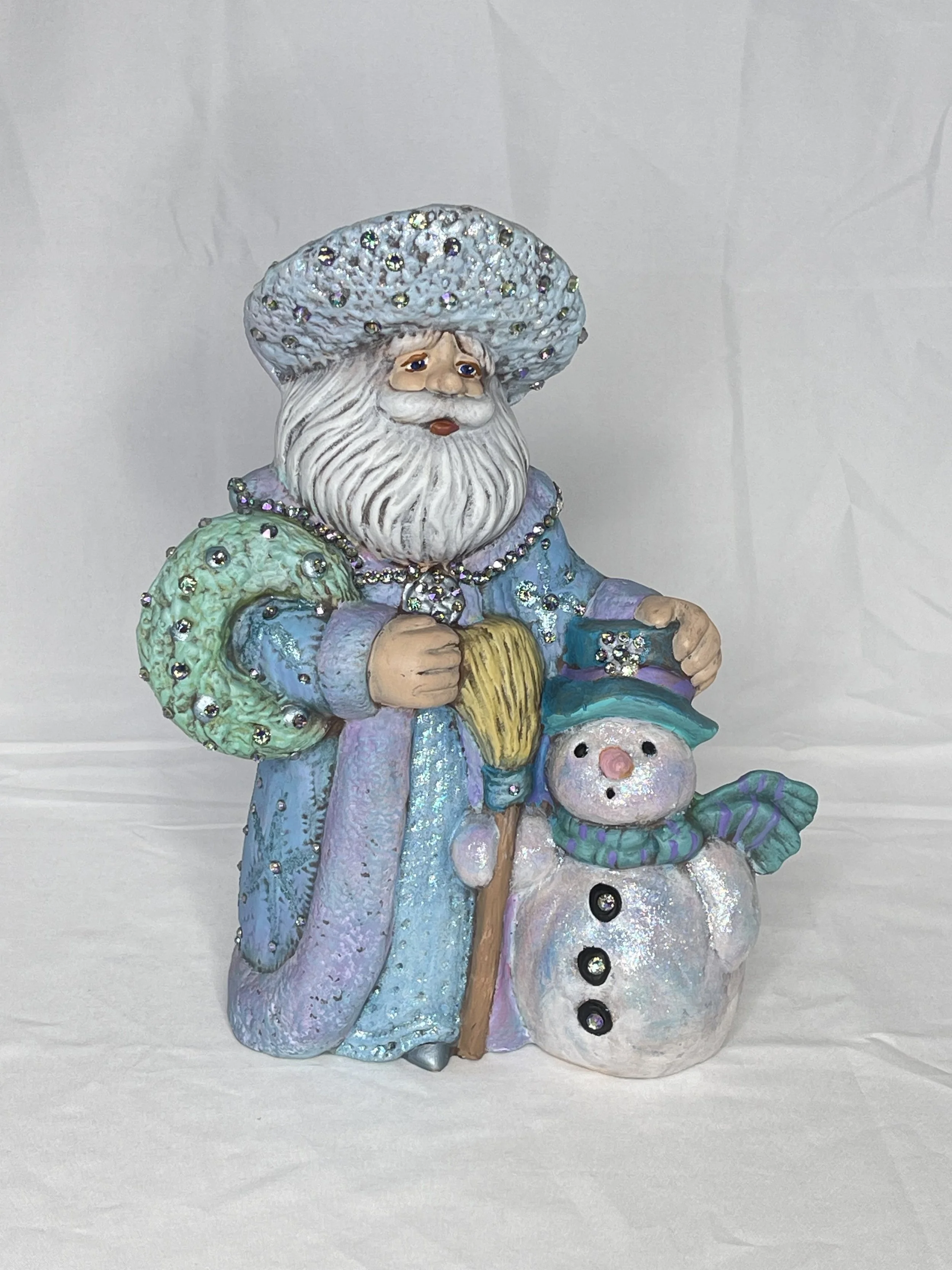 Decorative figurine of Santa Claus with a snowman, dressed in pastel colors and adorned with rhinestones.